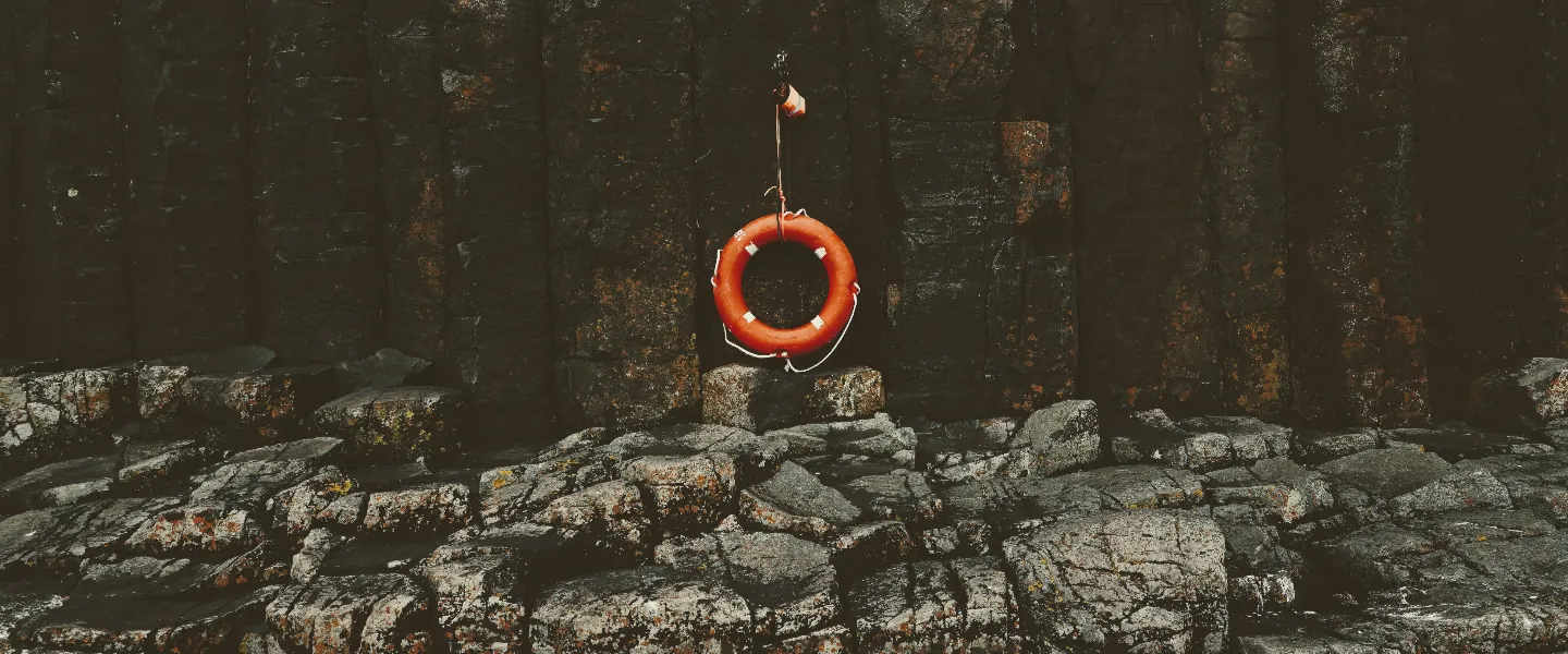 Vista desde el mar de un salvavidas colgado de una pared de un acantilado