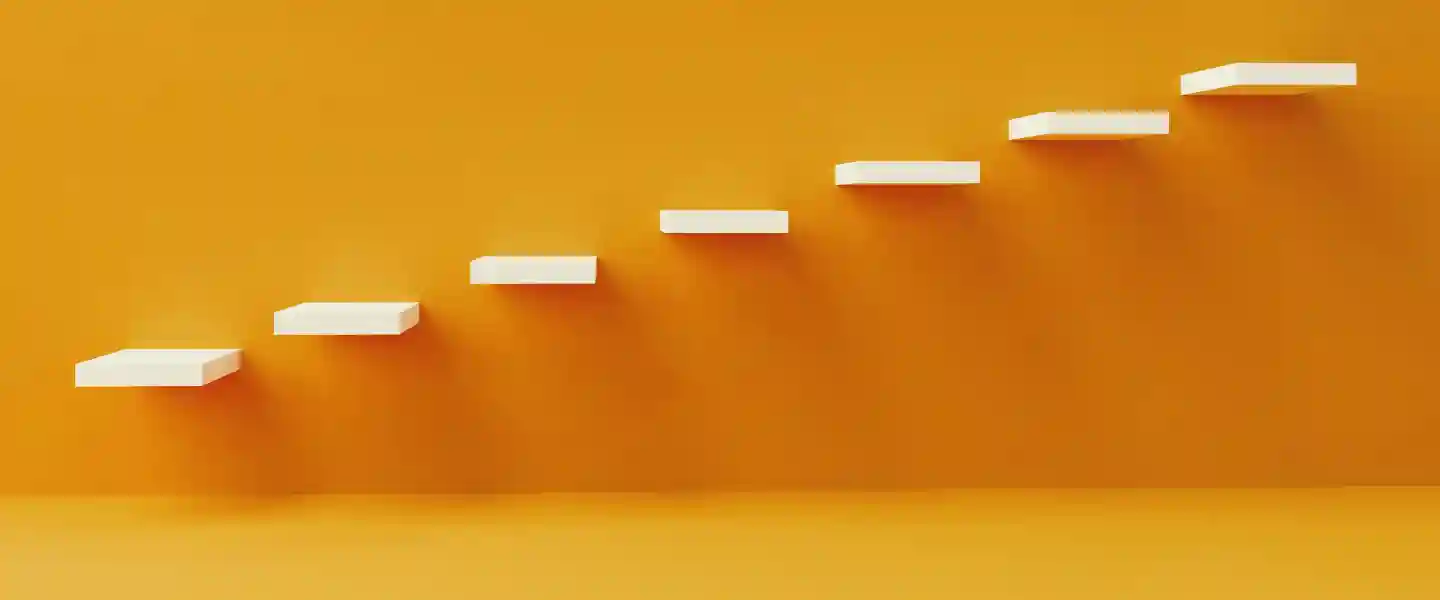 Ecalones amurados de una escalera blanca sobre una pared naranja