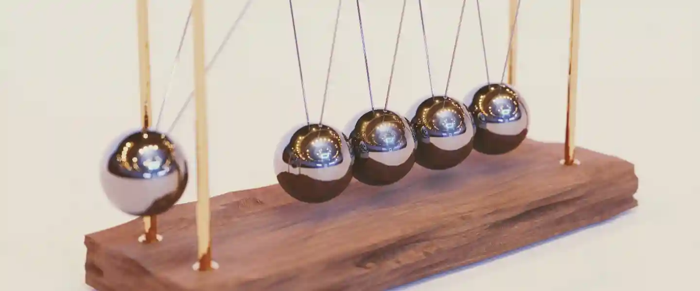 Un péndulo de Newton sobre una base de madera.