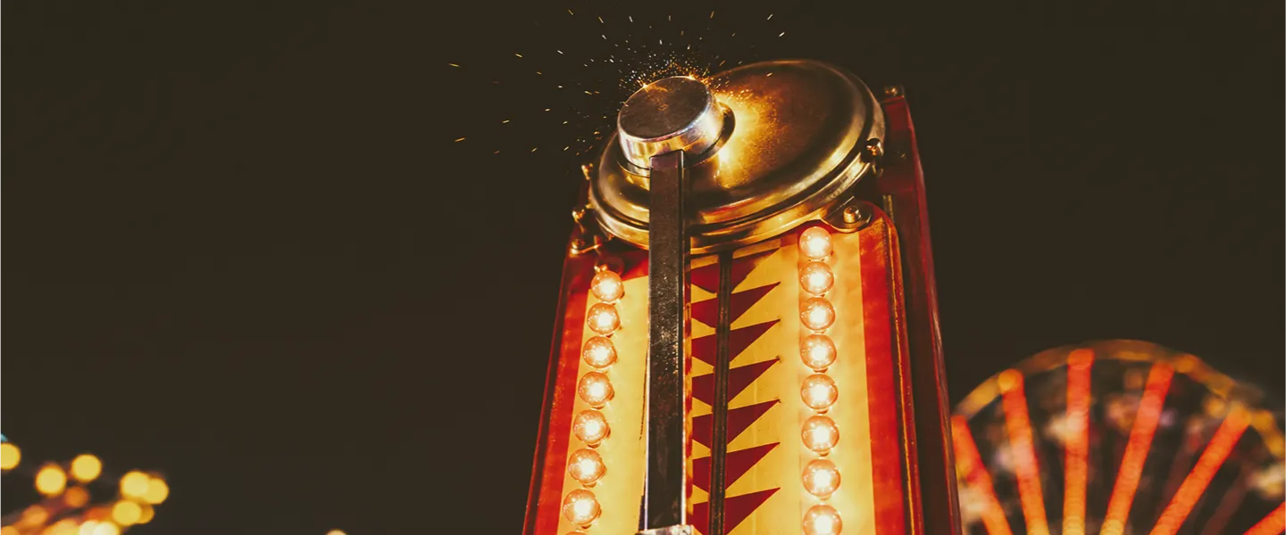 Primer plano del golpe ganador de la campana en el juego de feria para medir fuerza con un mazo