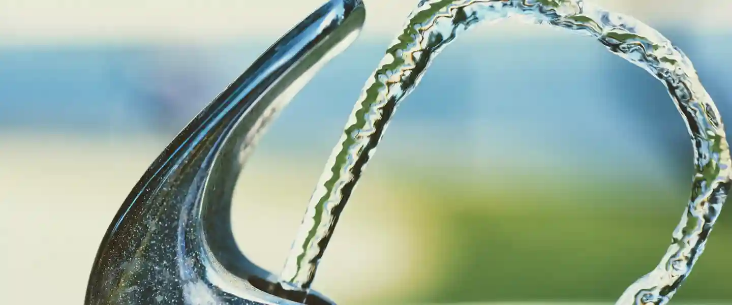 Chorro de agua saliendo de un bebedero en un dia soleado