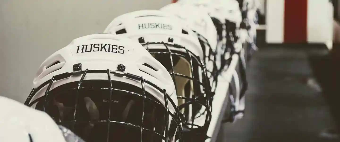 Cascos de hockey sobre hielo alineados sobre un banco