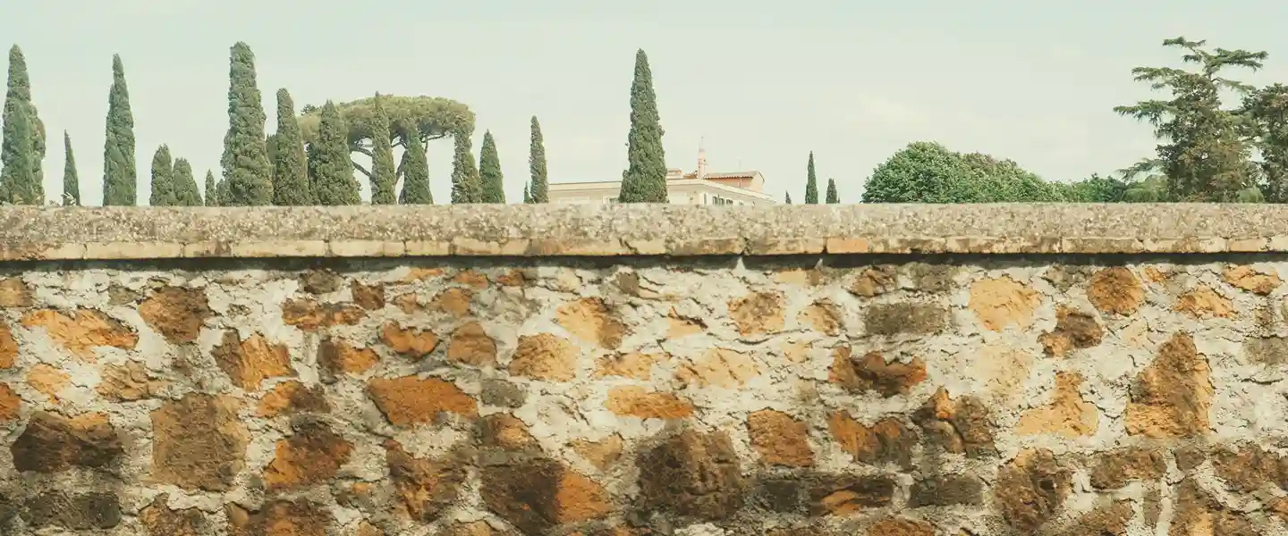 Gran muralla de piedra que separa al espectador de un poblado