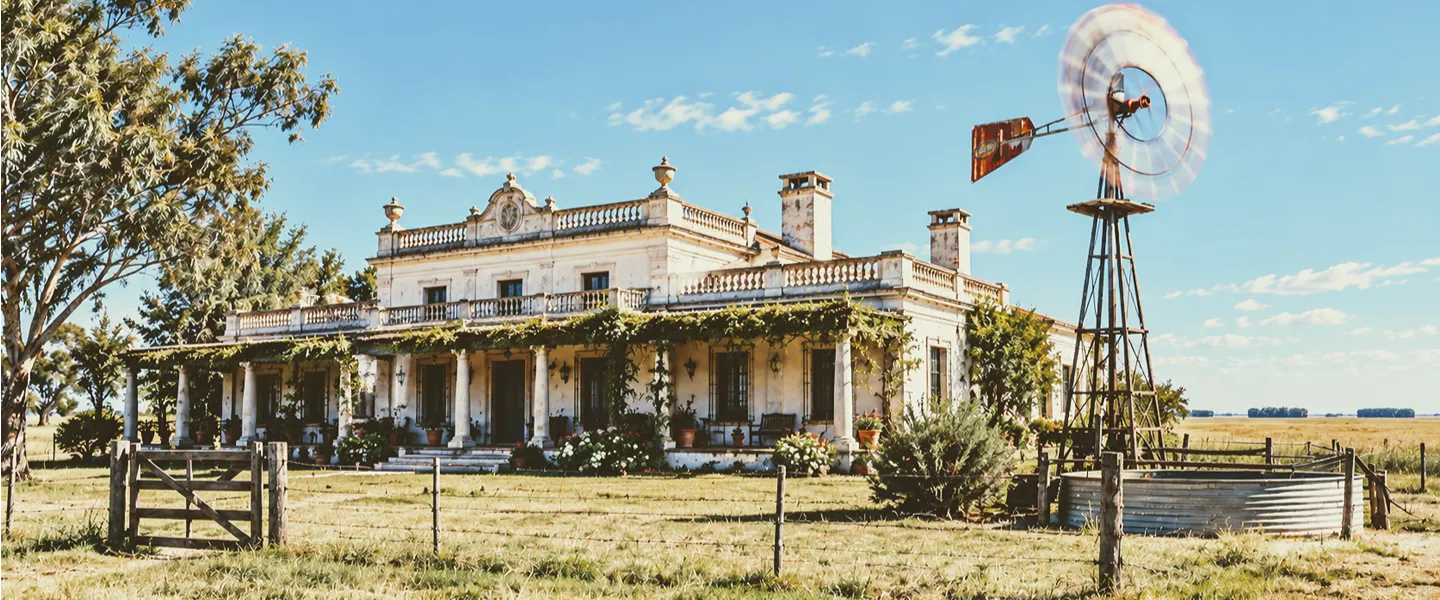 Estancia típica de la pampa con un molino de viento andando a toda velocidad
