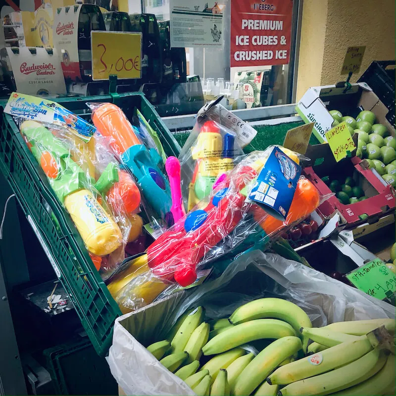 Photo of a fruit stall with water pistols on display