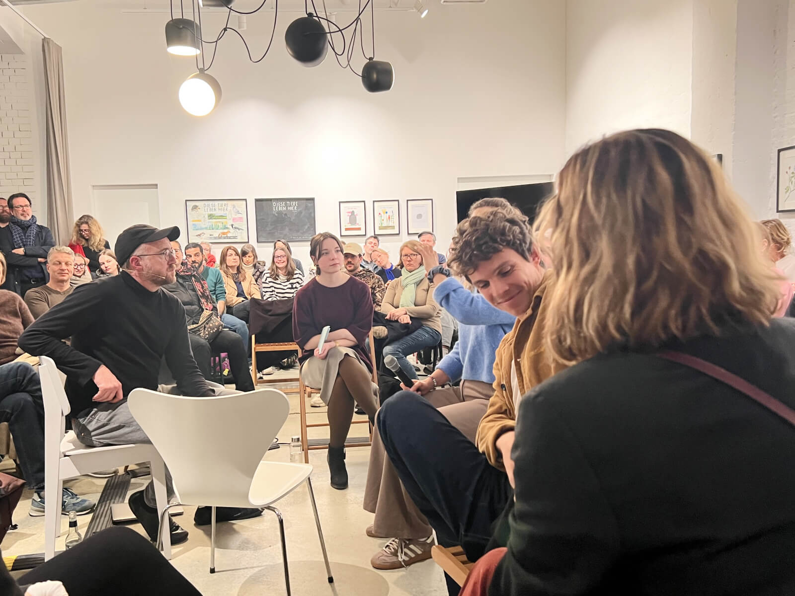 Nahaufnahme der Talkgäste und des Publikums beim SIMPLEX Event. Die Teilnehmenden sitzen in einem Stuhlkreis und lauschen dem Gespräch in einer konzentrierten, aber entspannten Atmosphäre.