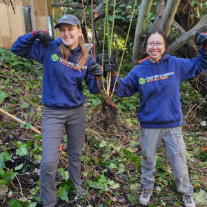 A staff worker in a field showing thumbs up