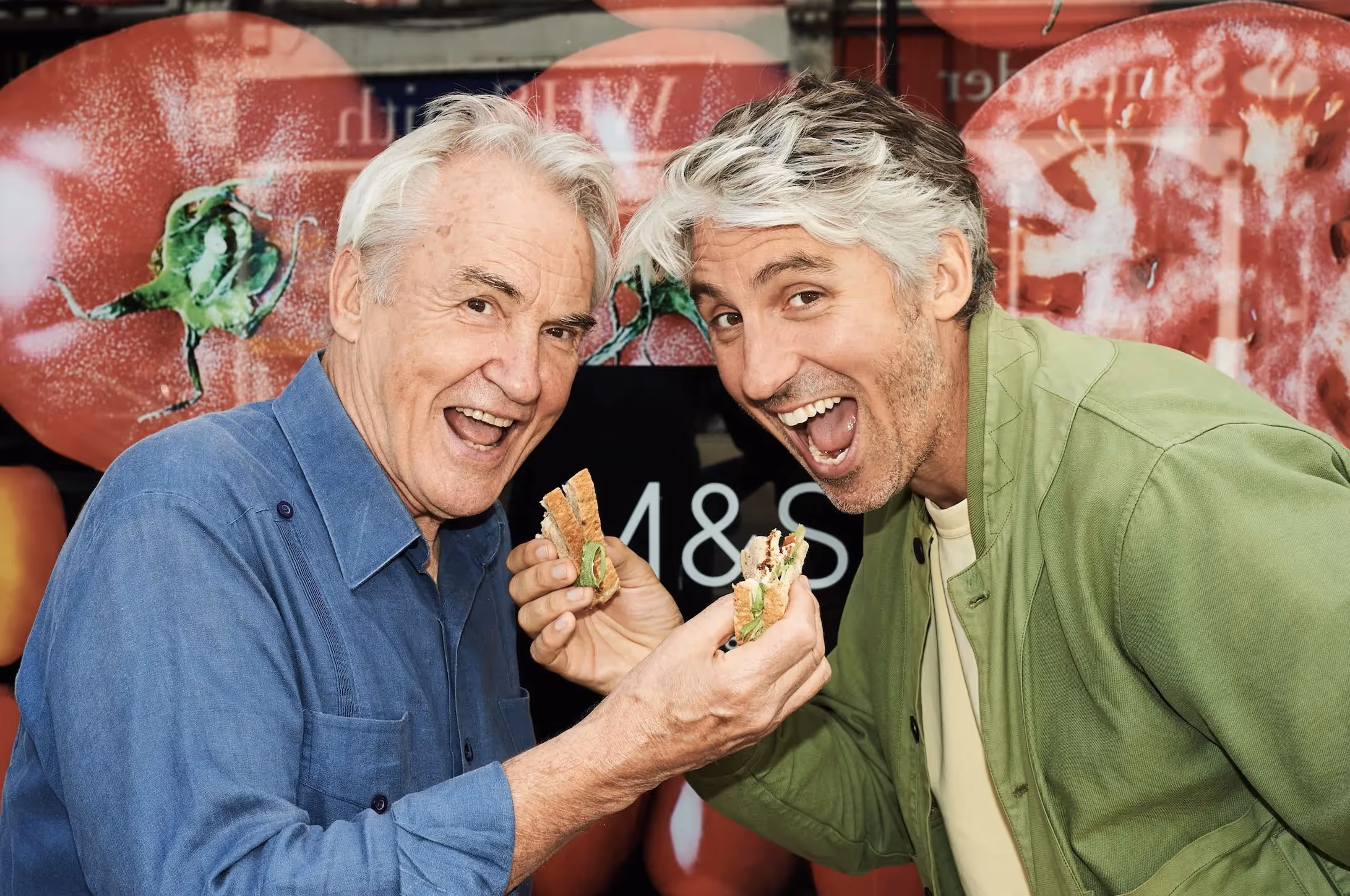 Two founders smiling, holding regenerative bread loves by Mark&Spencer and Wildfarmed