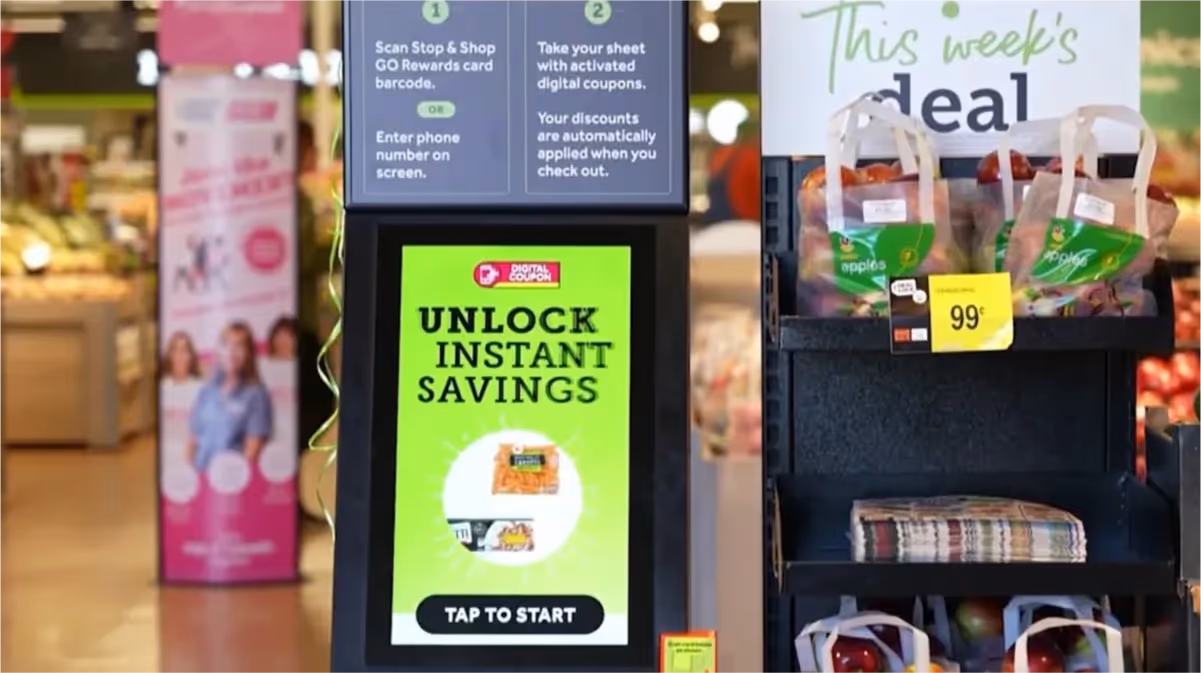 Kiosk in Stop and Shop supermarket with 'Unlock instant savings' on the digital screen