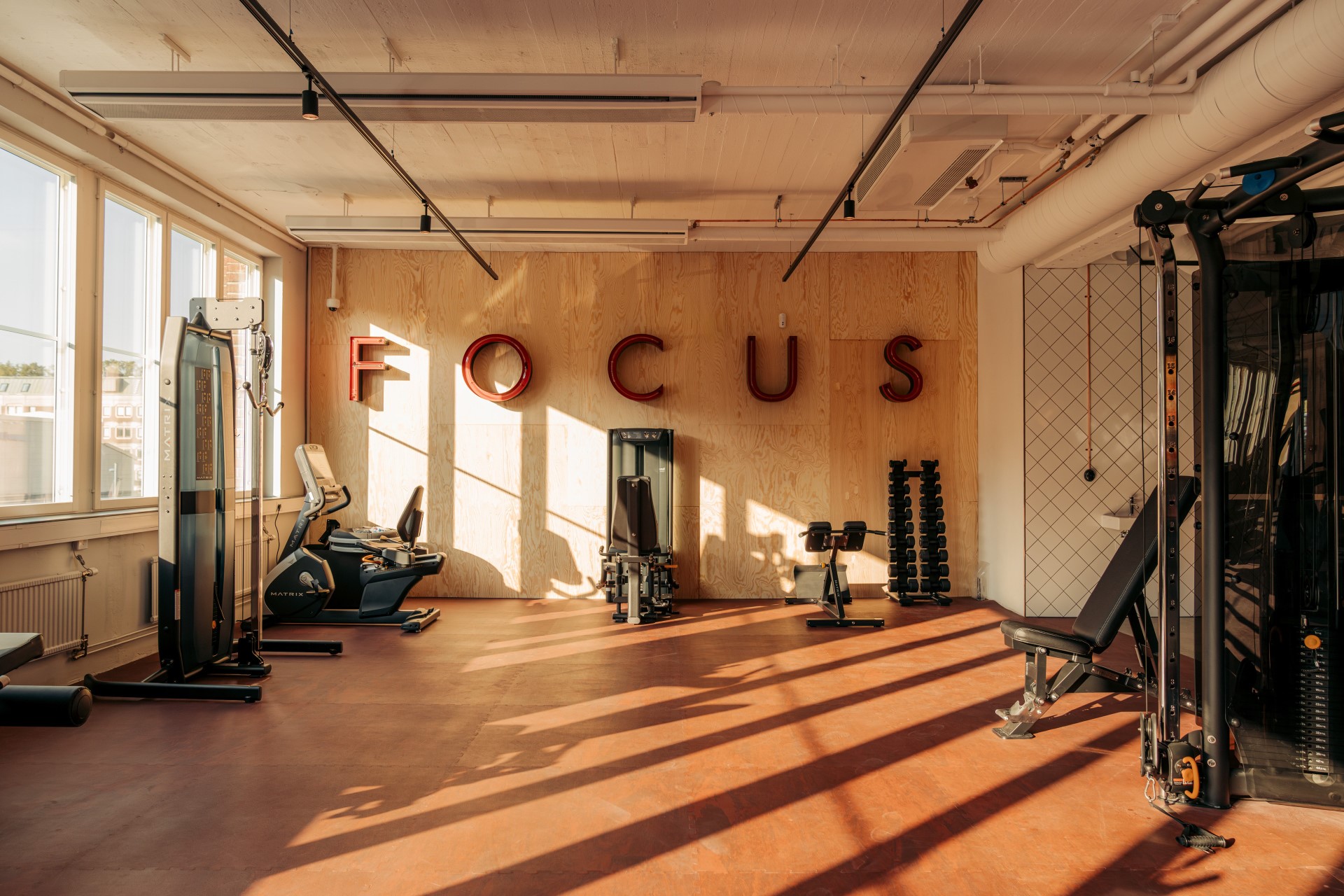 Sunlit training area with timber wall panels, red flooring and large FOCUS lettering.
