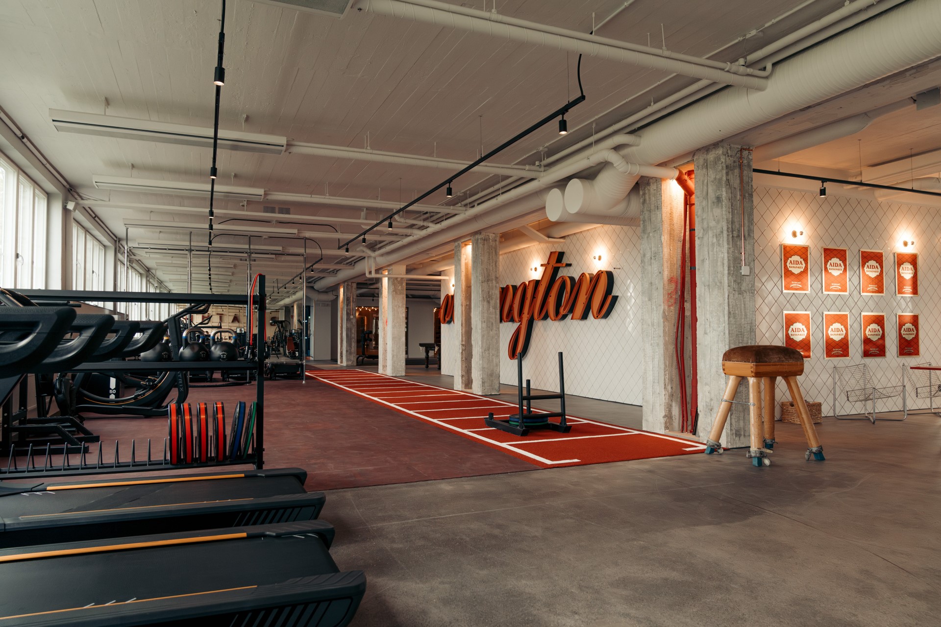 View along the gym's red training lane with warm lighting and Mornington wall lettering.