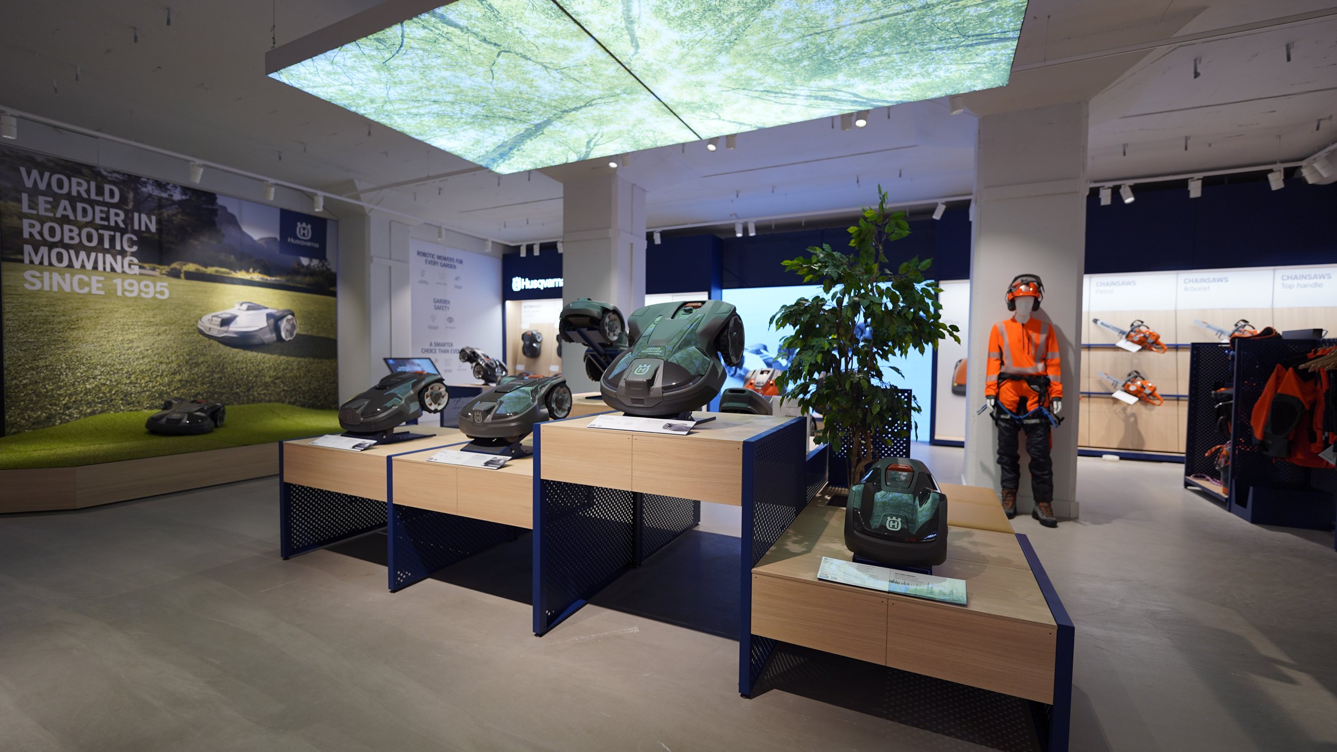 Husqvarna pilot store showing a nature projection above modular mower displays