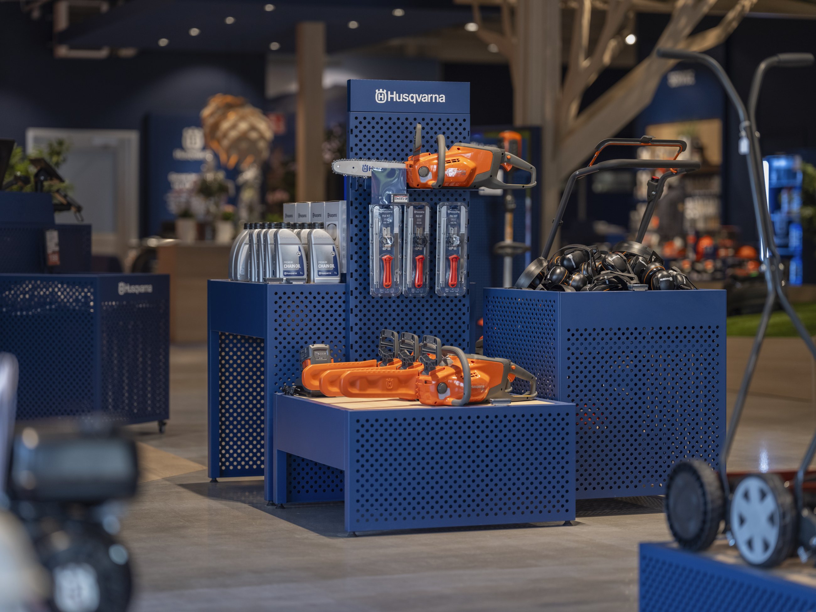 Husqvarna tools arranged on blue modular retail fixtures
