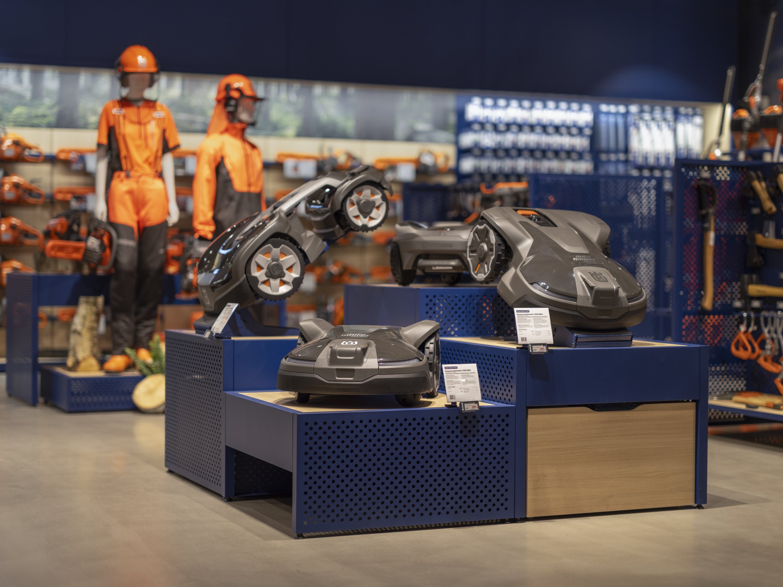 Husqvarna equipment presented on a modular blue and wood display