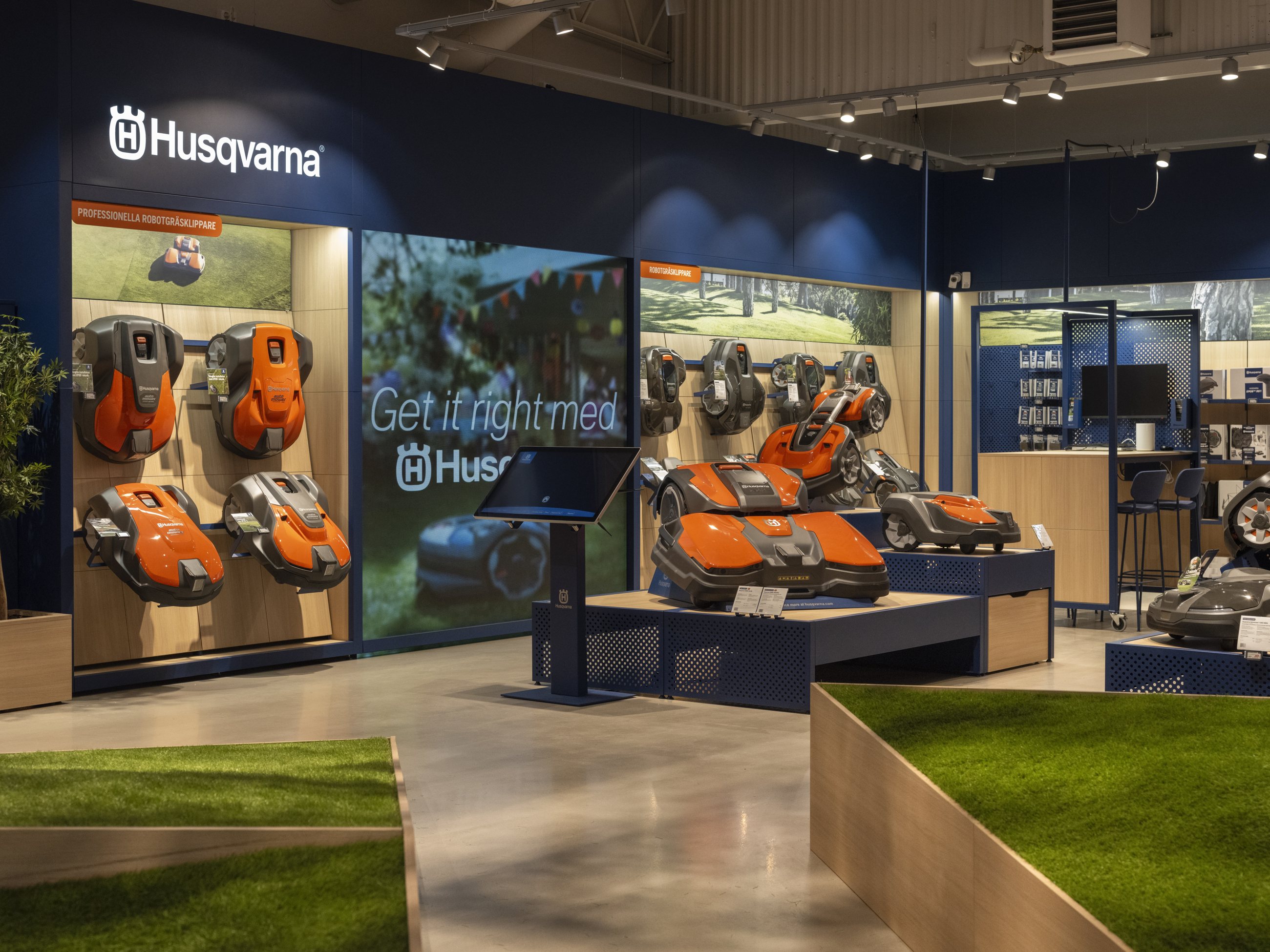 Husqvarna retail interior with outdoor equipment, blue fixtures and turf display