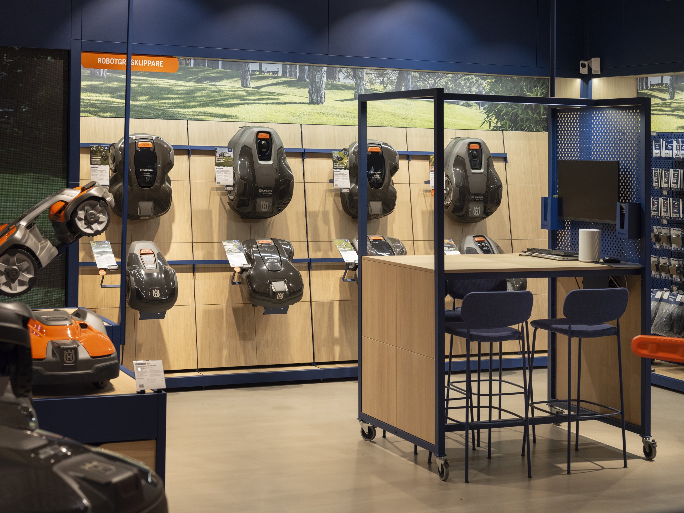 Husqvarna robotic mower wall display beside a consultation table