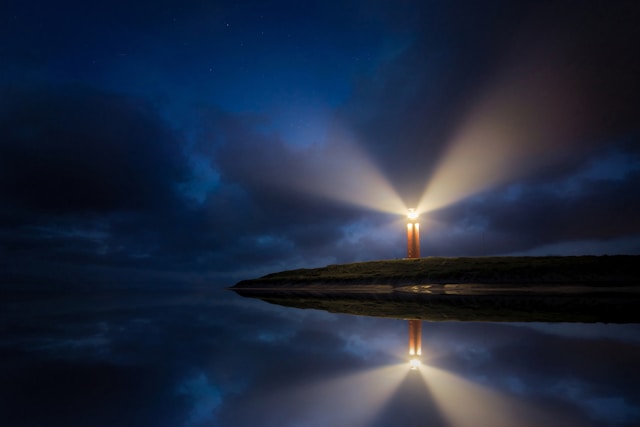 Lighted brown lighthouse near a body of water. Photo by Evgeni Tcherkasski on Unsplash.