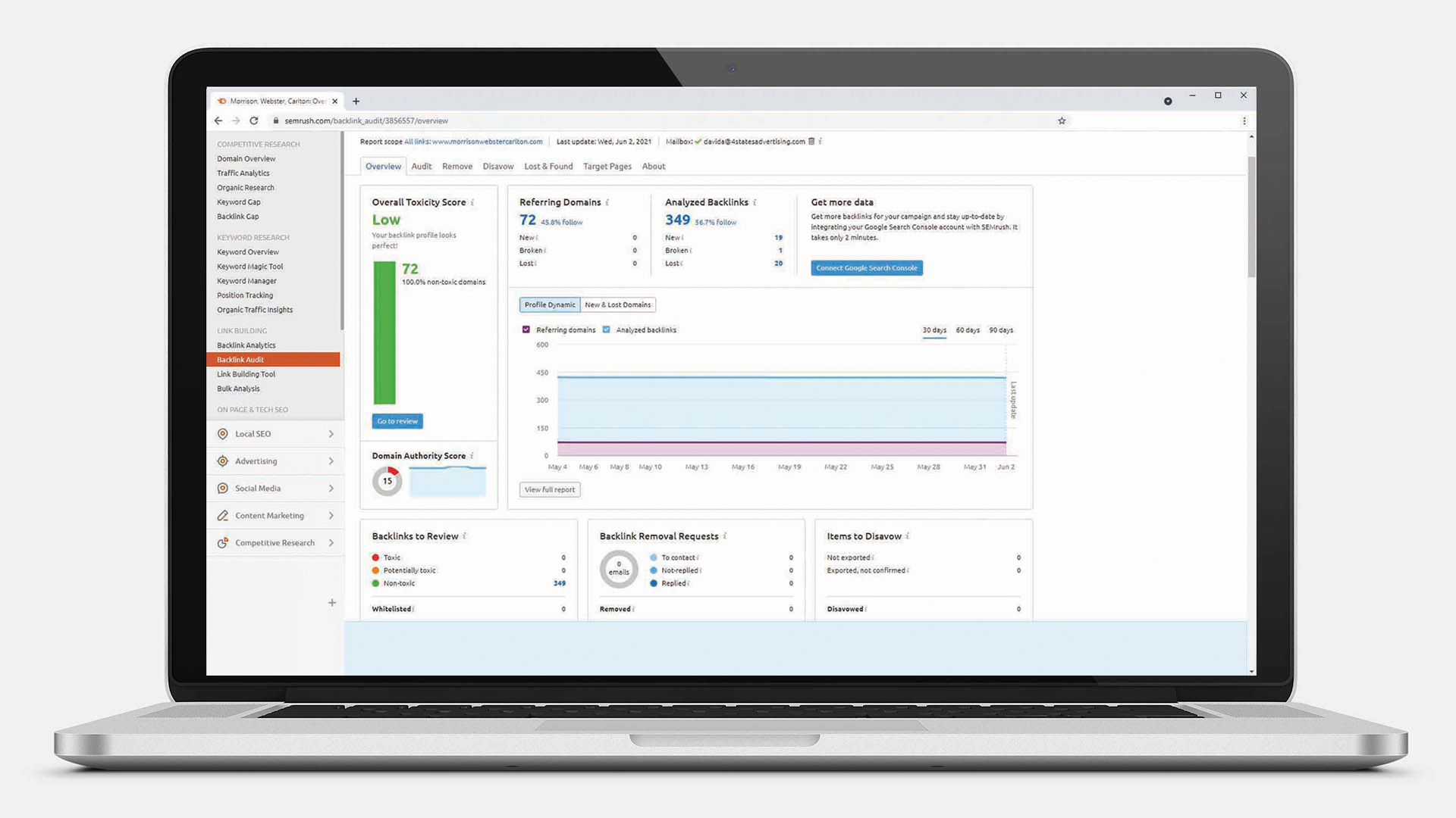 Laptop displaying SEMrush backlink audit dashboard showing overall toxicity score, referring domains, analyzed backlinks, and backlink metrics.