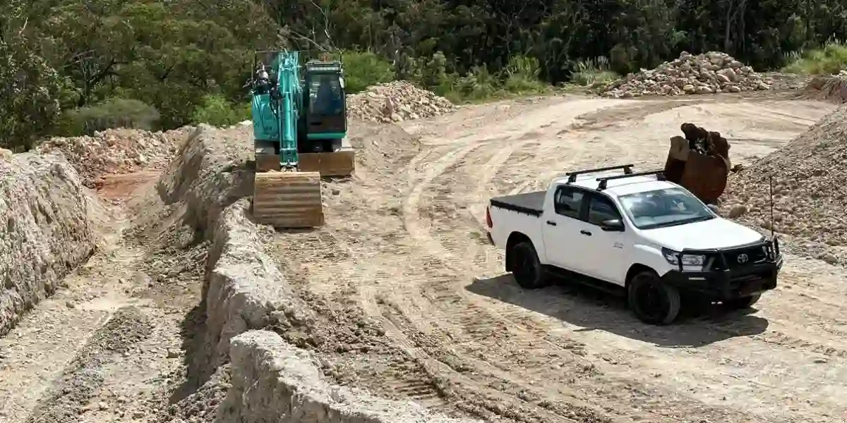 Field vehicle and monitoring equipment at an excavation site.