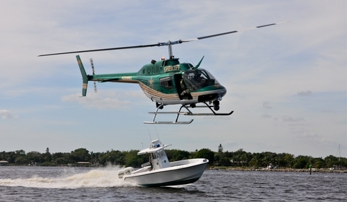 Florida sheriff helicopter flying over speedboat in the water