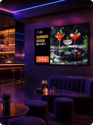 Lounge area with a neon-lit bar and a screen showing a summer offer for cocktails: buy 2 get 3.