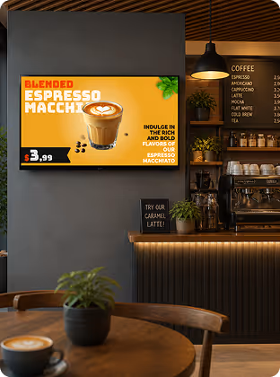 Cafe interior with espresso macchiato sign, coffee menu, and a table with coffee and plant.