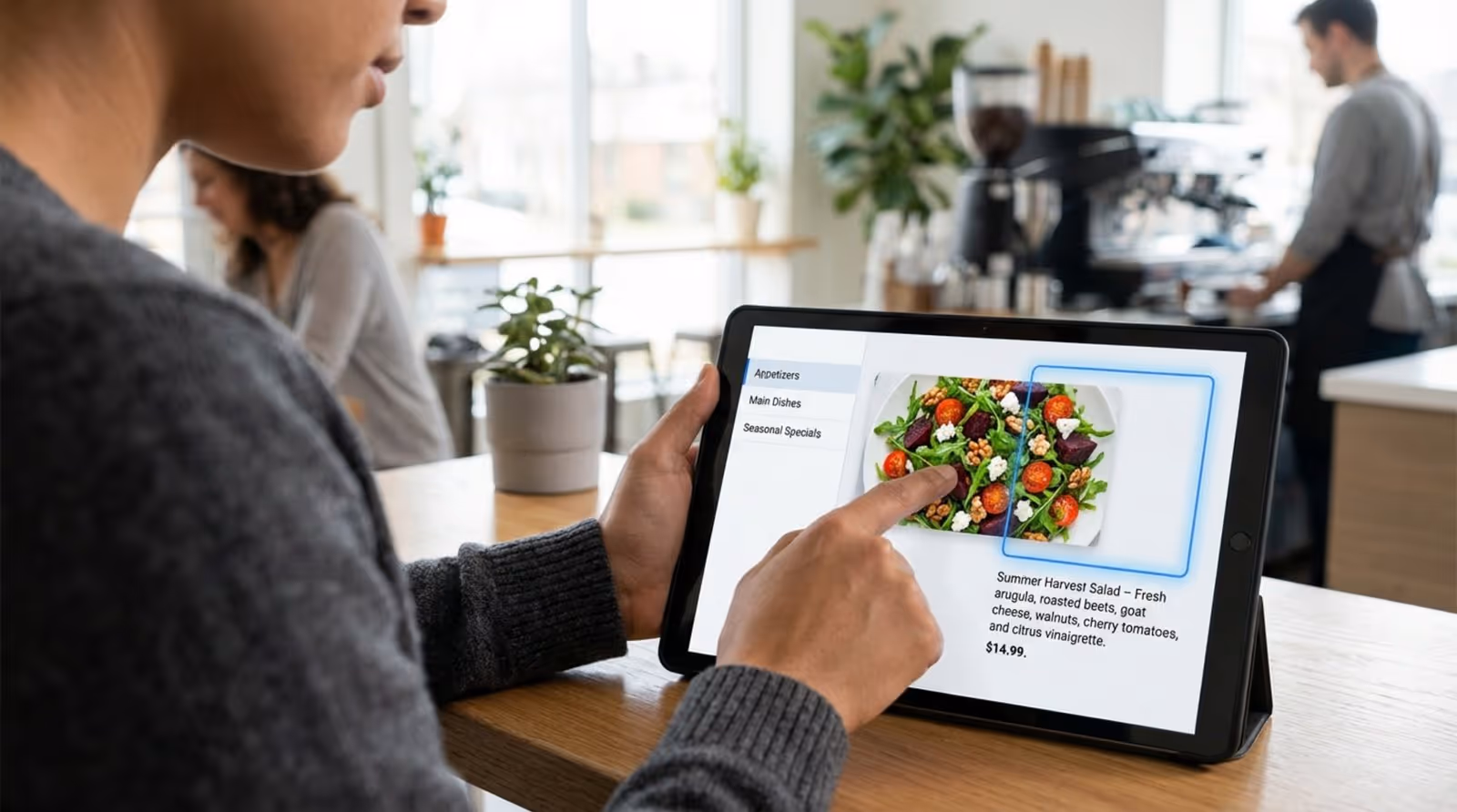 A person edits a digital menu on a tablet, dragging a seasonal salad image into a template layout for quick updates.