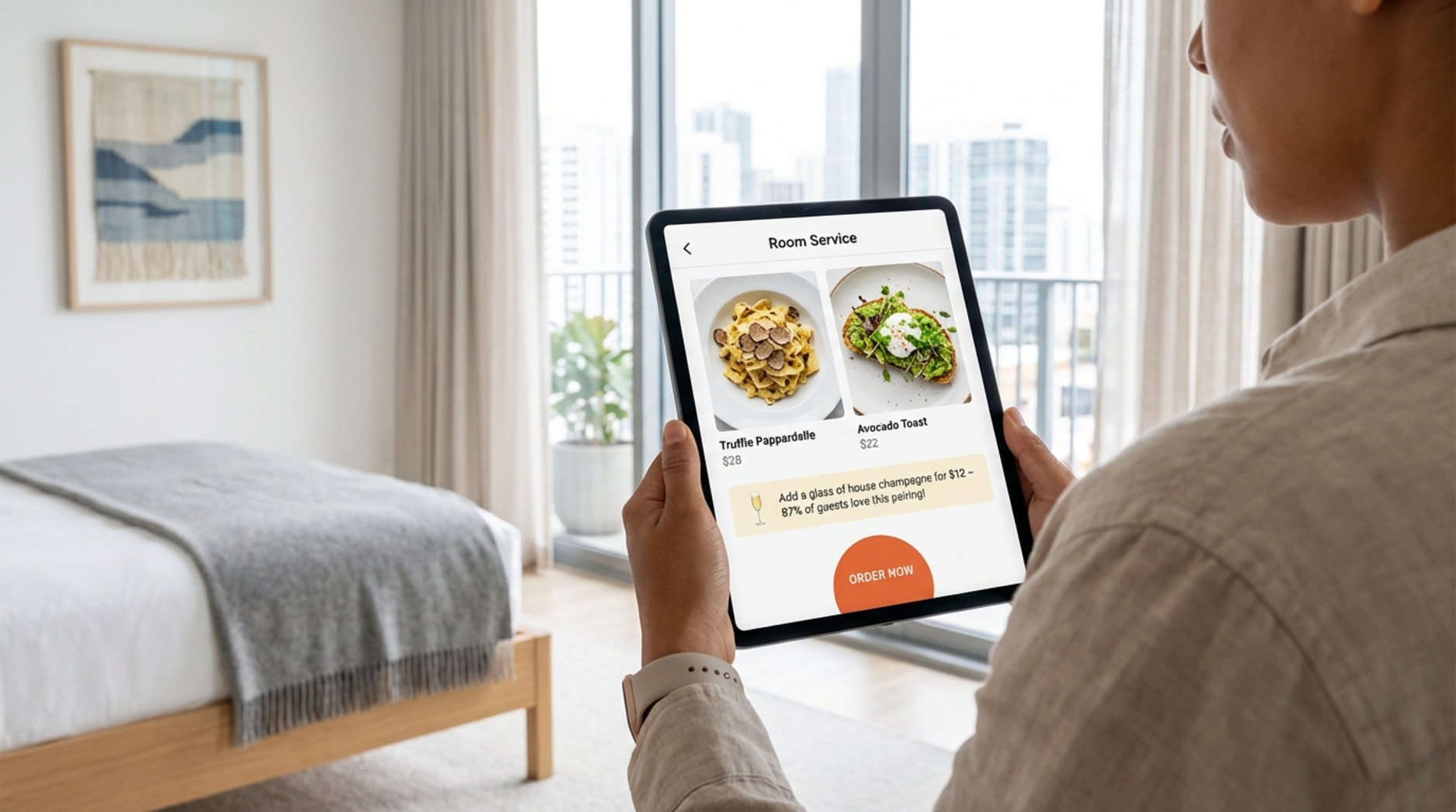A guest relaxes in a modern hotel room while browsing the digital concierge on a tablet displaying the room service menu with high-quality food images and an order button.