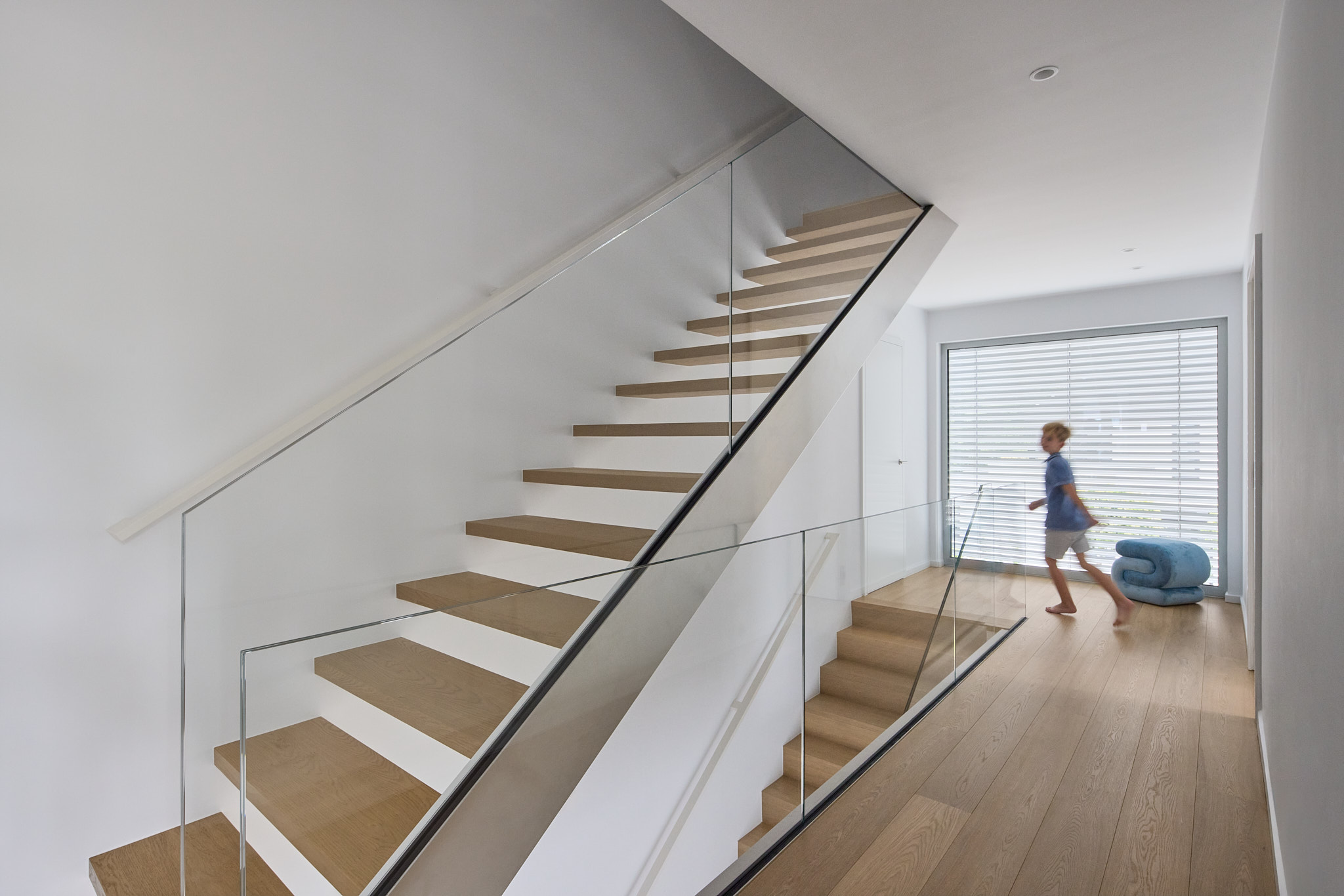 Ein Kind flitzt durch den Treppenaufgang – Momentaufnahme im Haus.