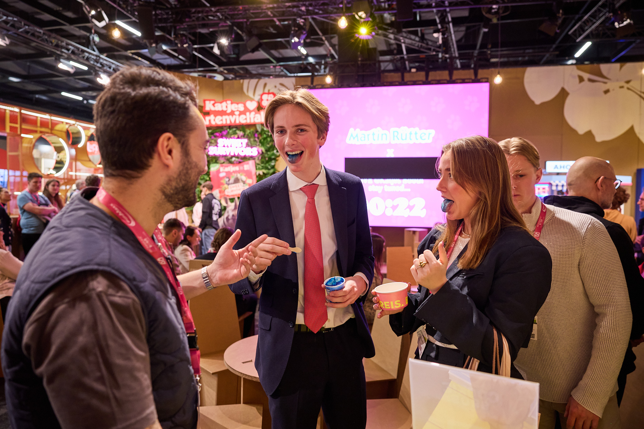 Messefotografie mit Besucher:innen beim Probieren von Süßigkeiten am Katjes Stand.