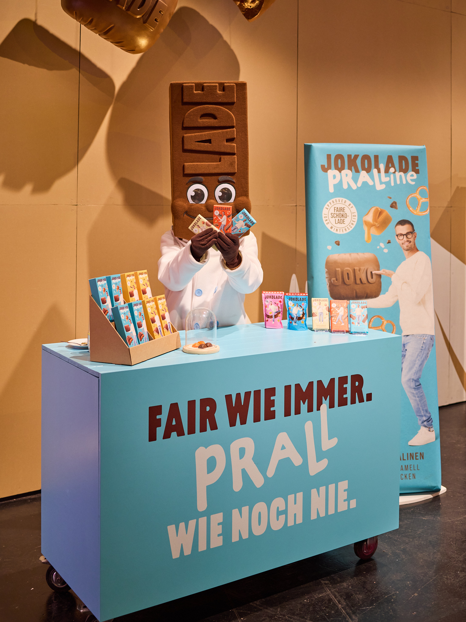 Messefotografie des Jokolade-Standes mit farbigem Branding, Maskottchen und Produktinszenierung.
