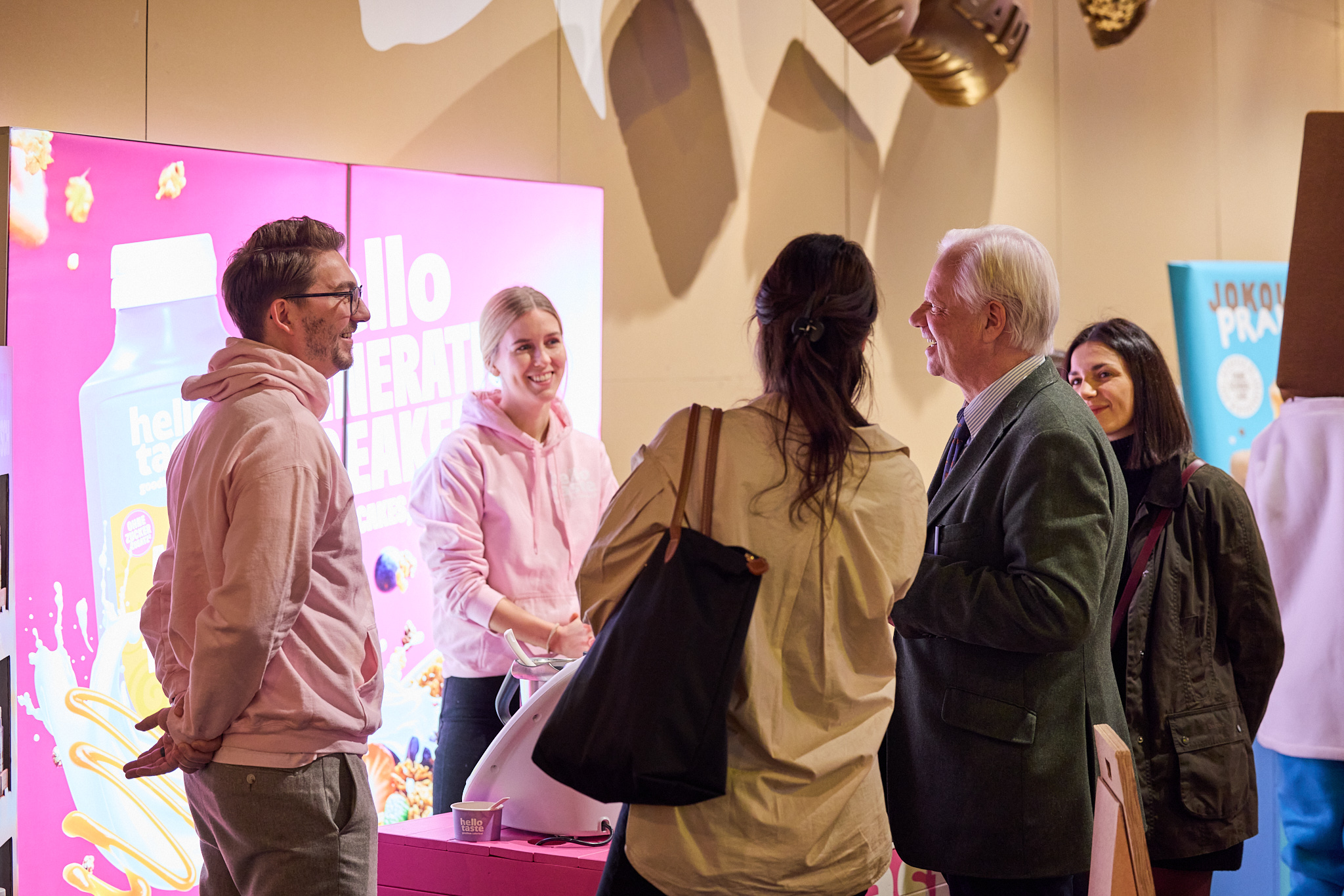 Fotografie der Menschen am und um den Messestand von Hello Taste.