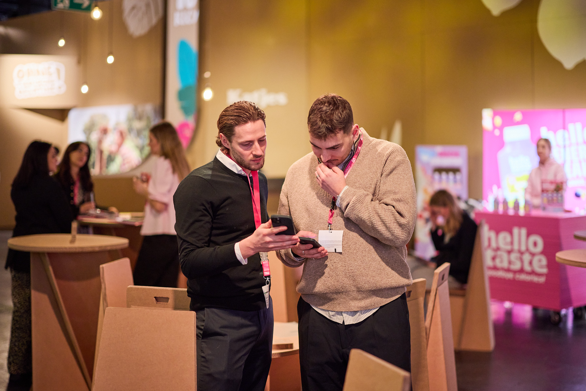 Messefotografie mit Fokus auf Besucher:innen und Markenarchitektur im Hintergrund.