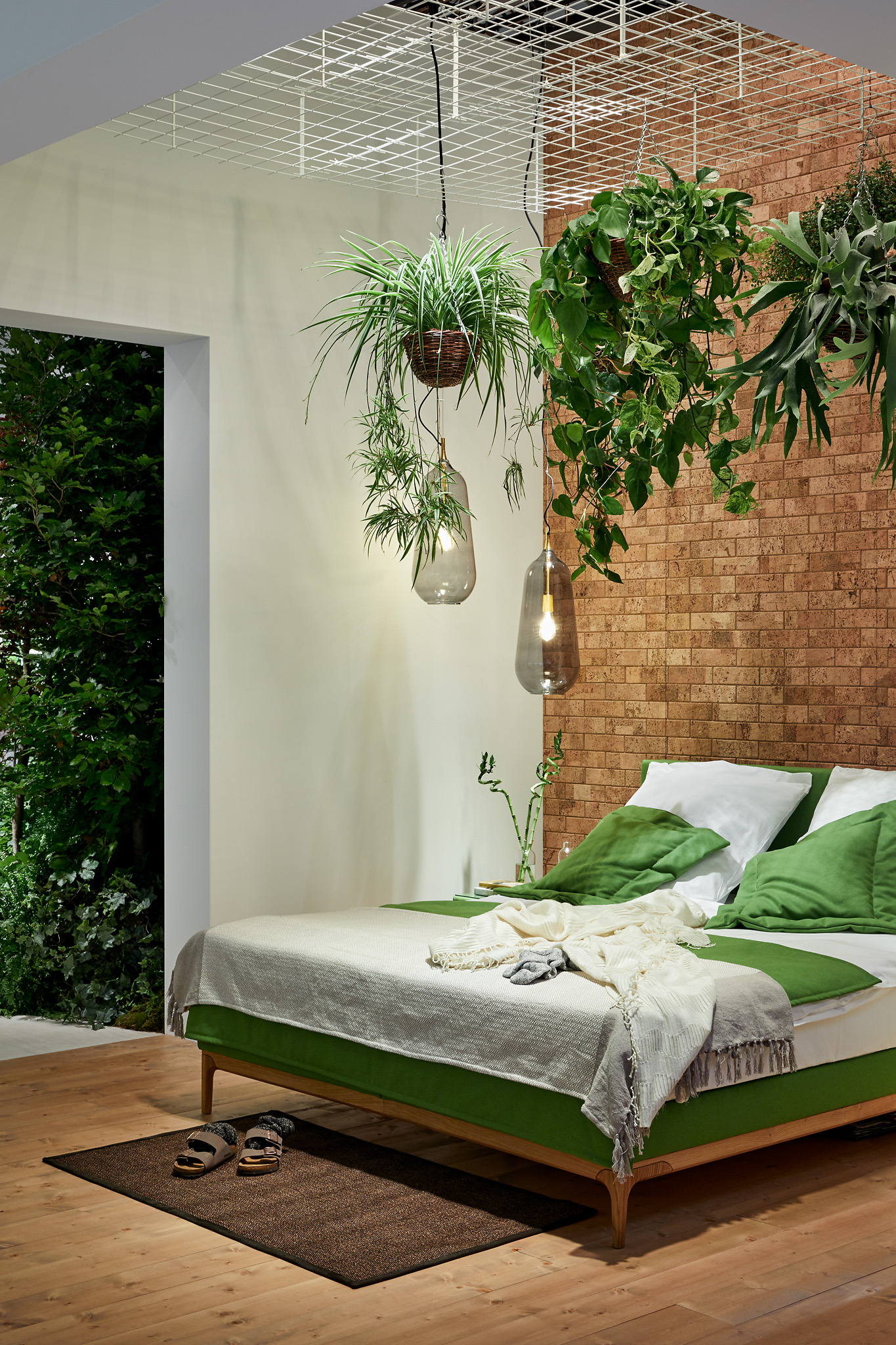 Schlafzimmer mit Korkwand und hängenden Pflanzen