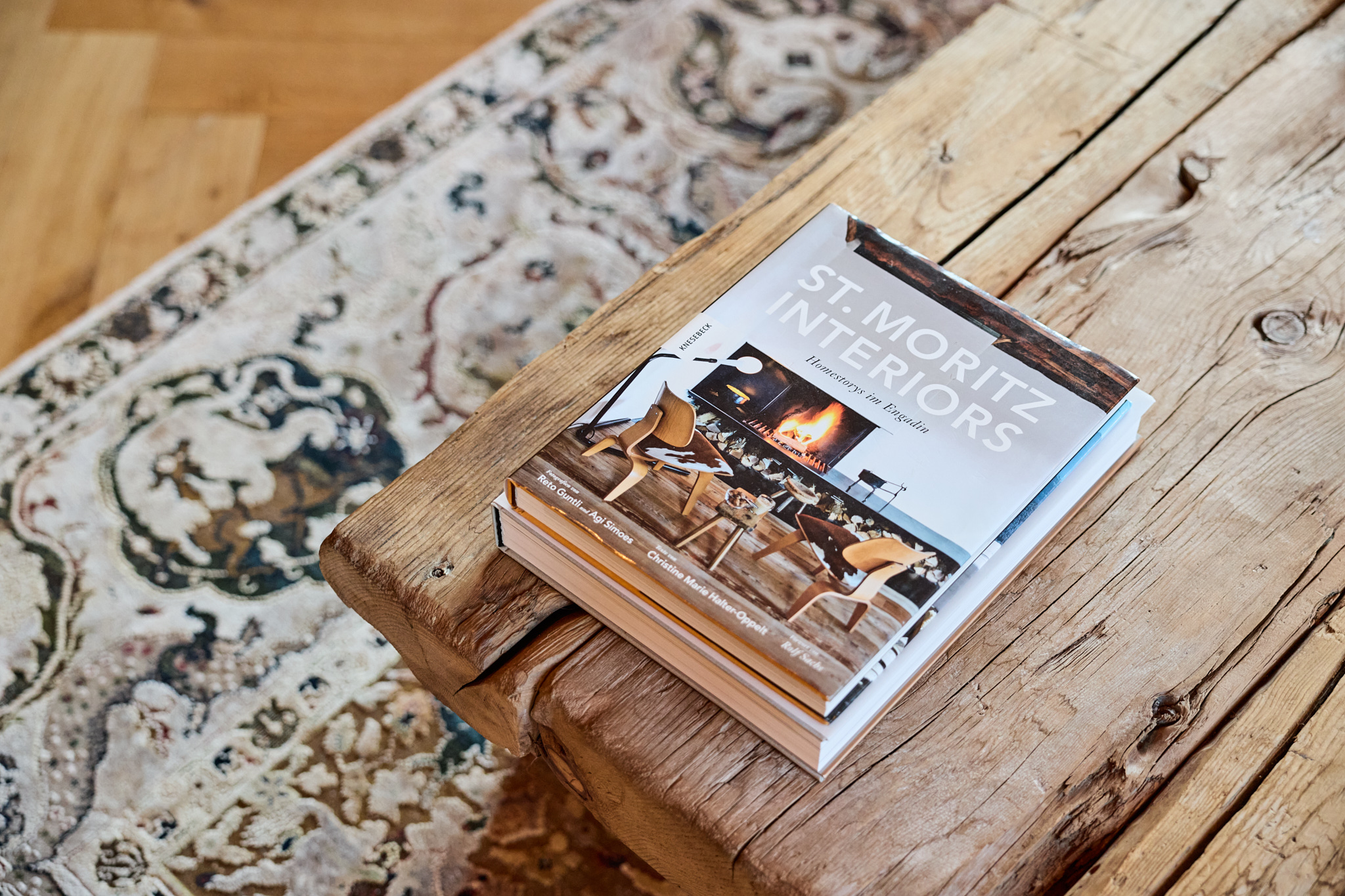 Nahaufnahme des Buchs „St. Moritz Interiors“ auf Couchtisch, stilvolle Fotografie mit Detailfokus.