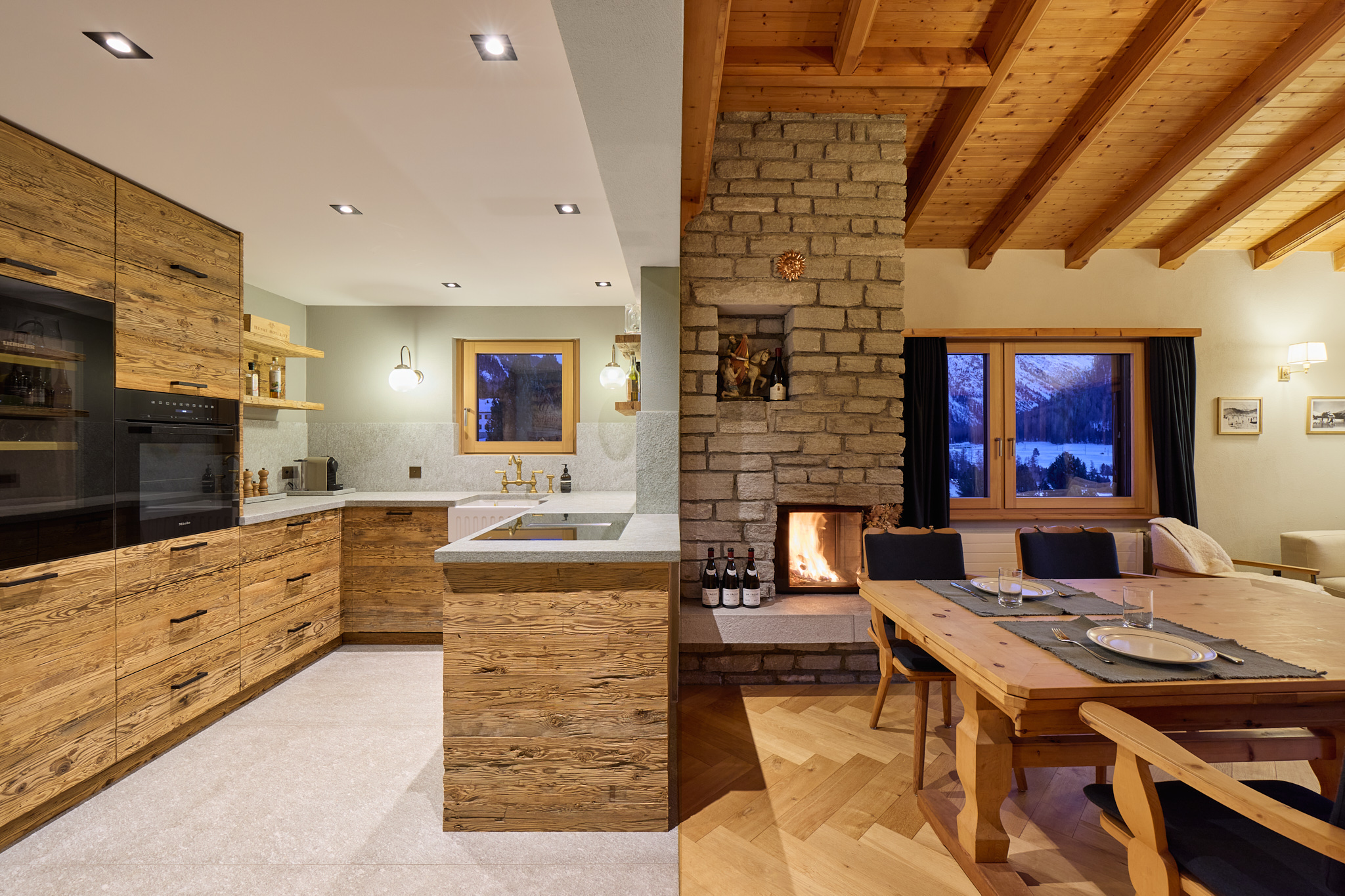Offener Blick in Küche und Essbereich mit Kamin, Architekturfotografie vereint Funktionalität und Gemütlichkeit.