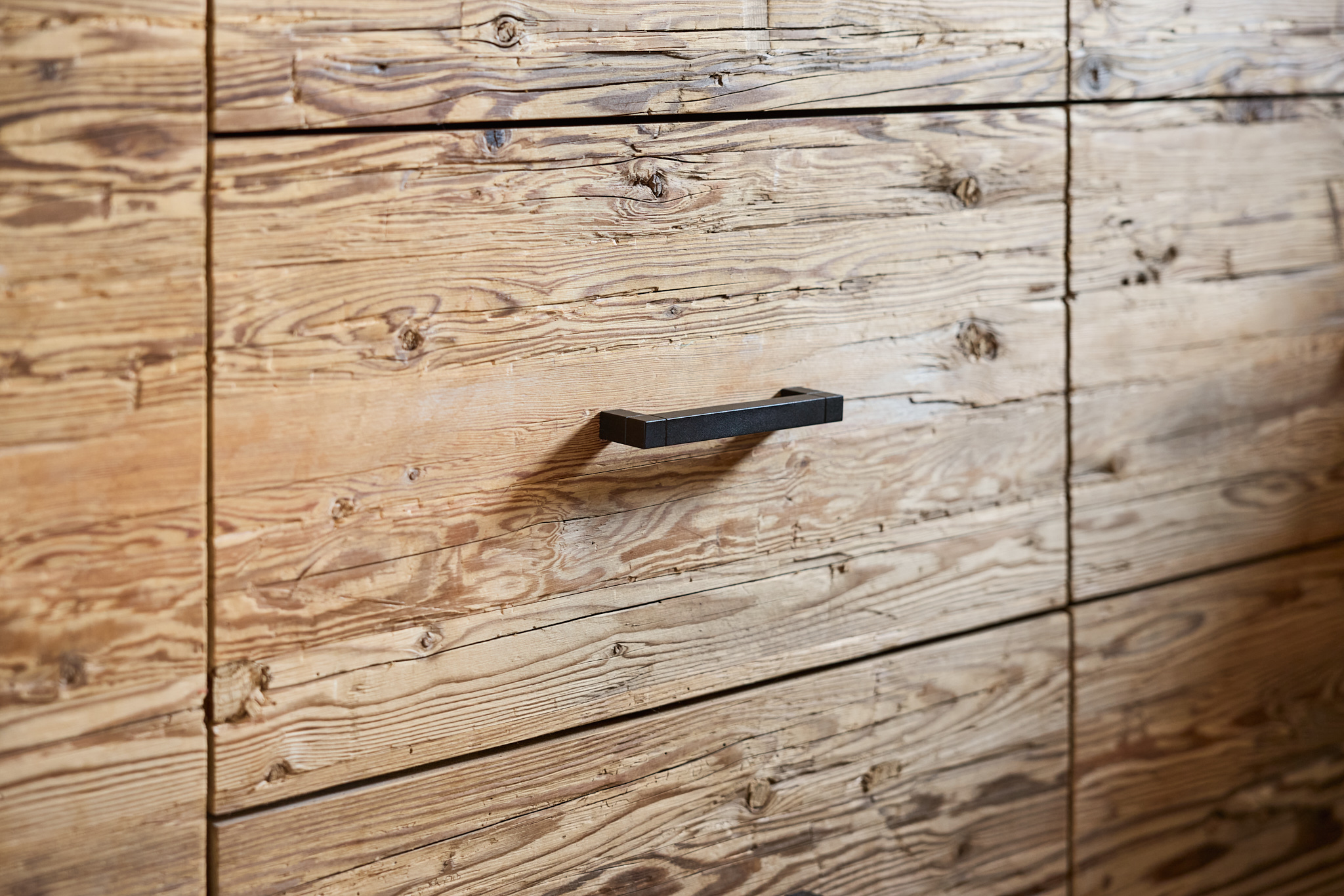 Nahaufnahme handwerklich gearbeiteter Holzelemente, Architekturfotografie mit Fokus auf Material und Detail.