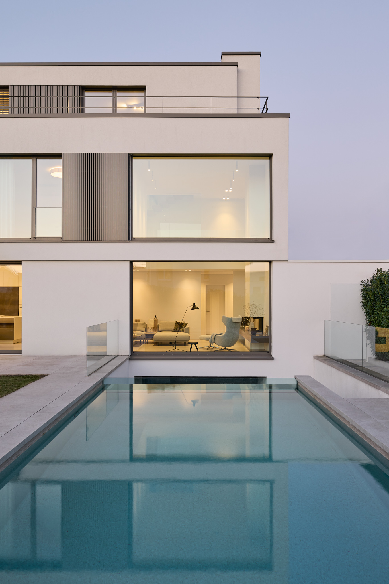Abendlicht spiegelt sich über Wasserfläche, stimmungsvolle Architekturfotografie.
