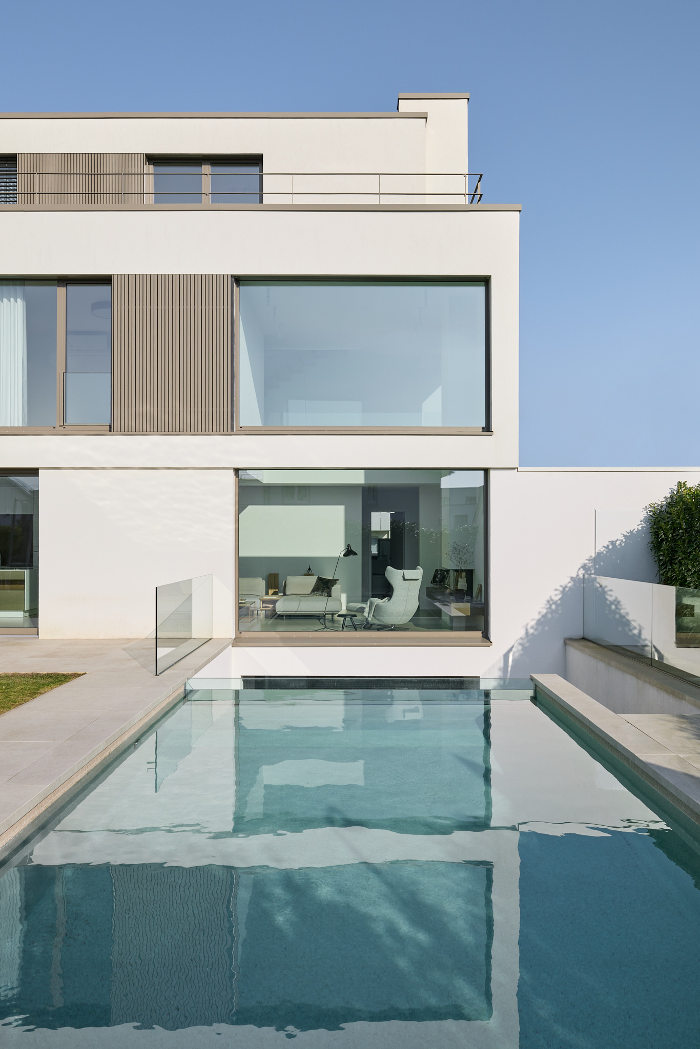 Blick über Wasserfläche am Pool bei Tageslicht, klare Architekturfotografie.