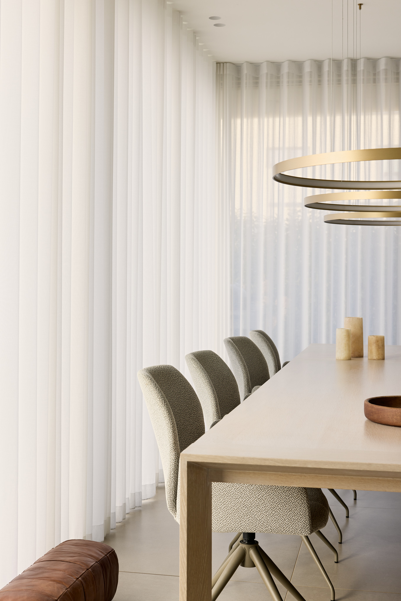Nahaufnahme Essbereich, stoffbezogene Stühle und heller Holztisch im minimalistischen Interior.