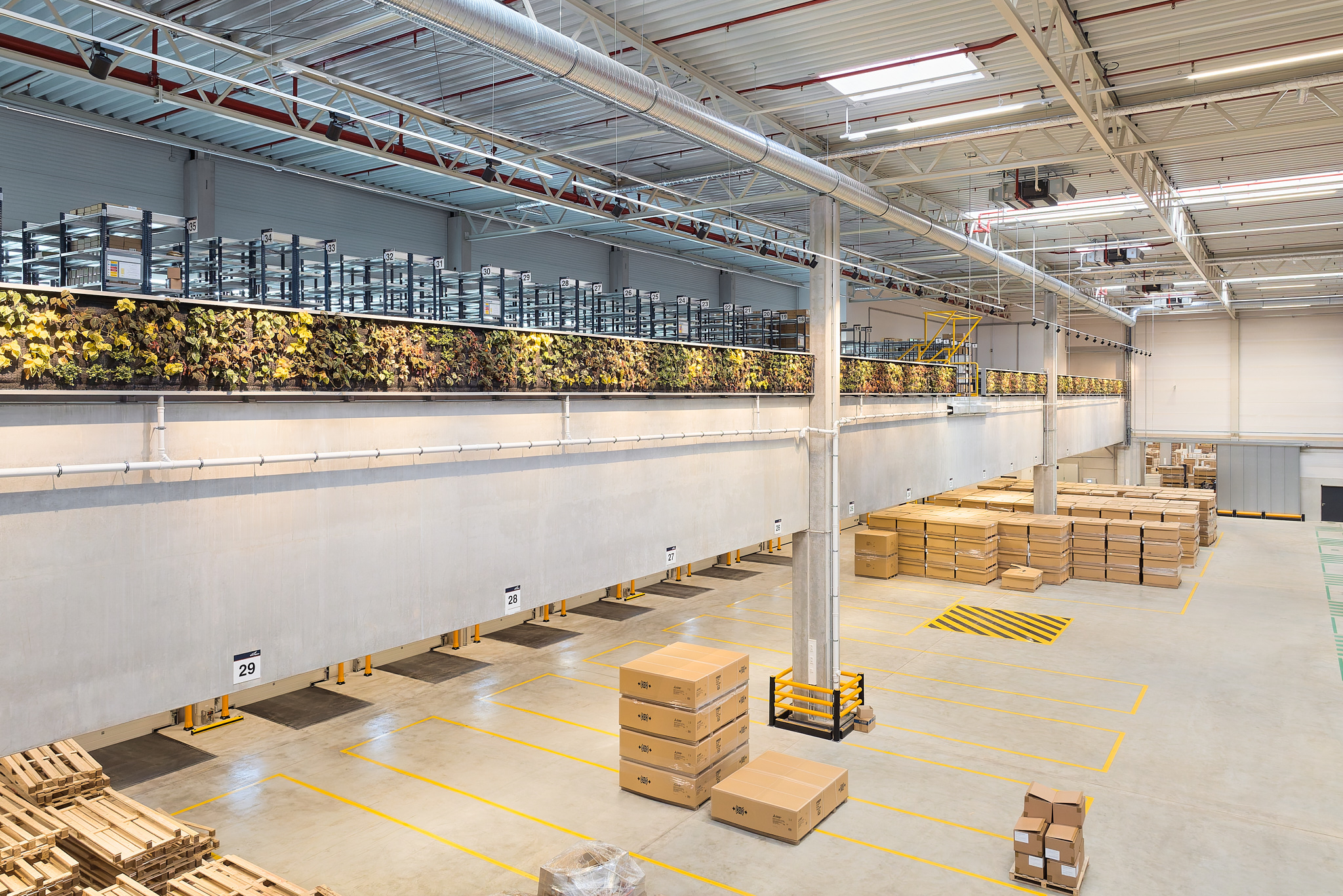 Begrünte Elemente in der Halle verbessern Luftqualität, nachhaltiges Logistikkonzept.