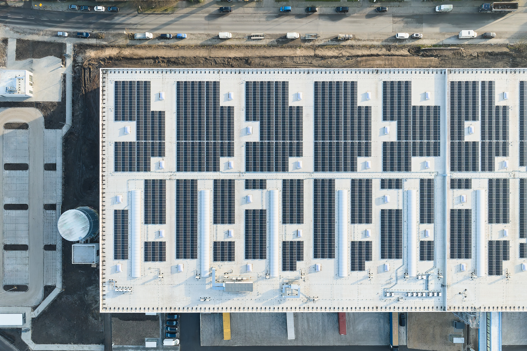 Dachaufnahme: Solaranlagen und Klimageräte in Vogelperspektive, nachhaltige Logistikarchitektur.