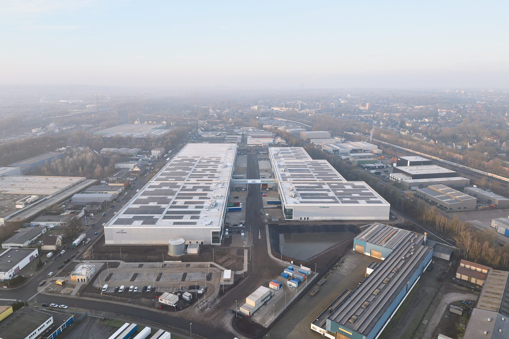 Drohnenaufnahme beider Hallen im sanften Nachmittagslicht, Architekturfotografie.