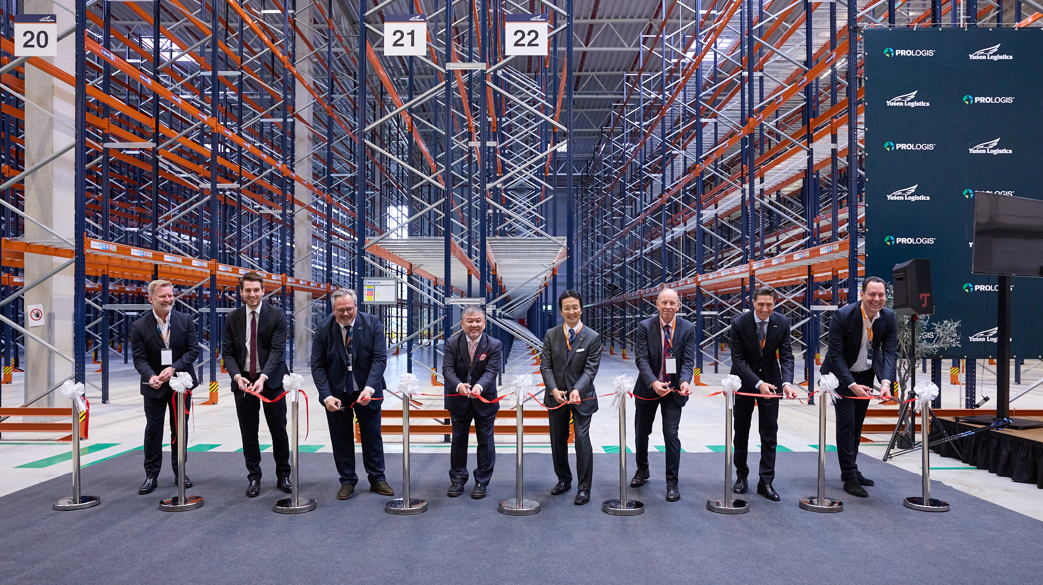 Durchschneiden des roten Bandes bei feierlicher Eröffnung des Logistikzentrums.