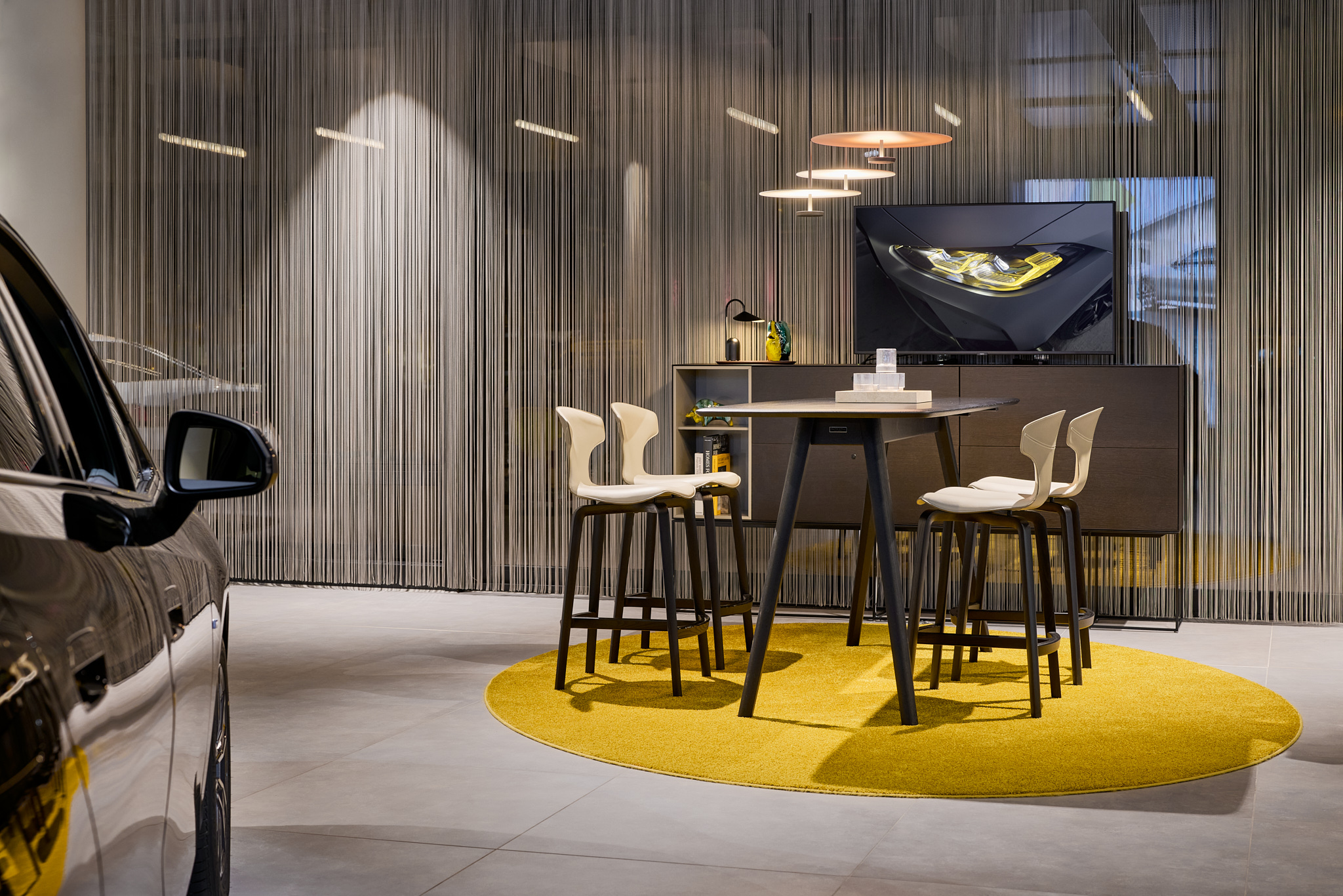 Sitzgelegenheit am Hochtisch mit Fadenvorhang, ruhige Atmosphäre im RetailNext Showroom.