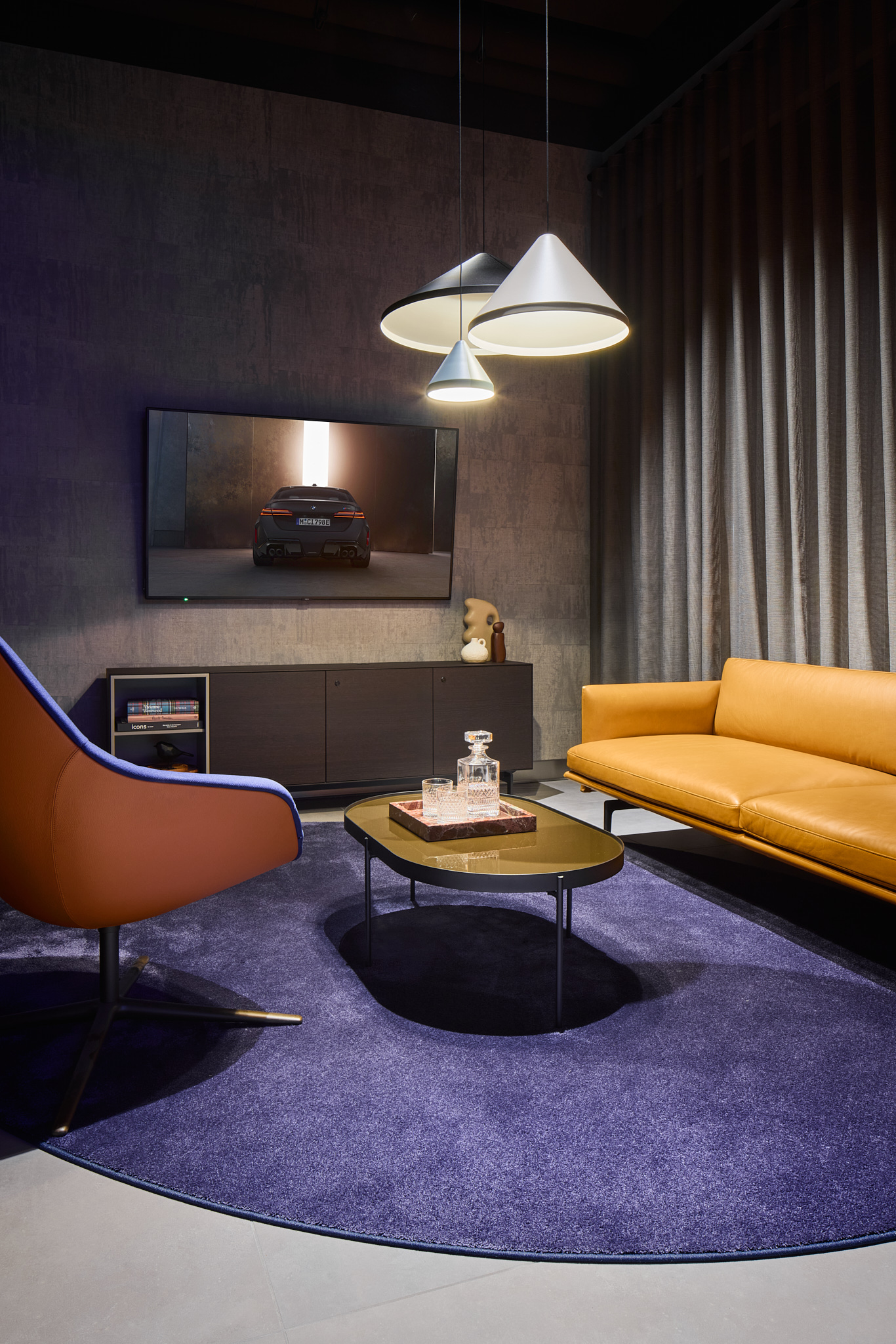 Lounge-Bereich mit Couch und Schalensesseln, wohnliche Markenarchitektur für BMW.