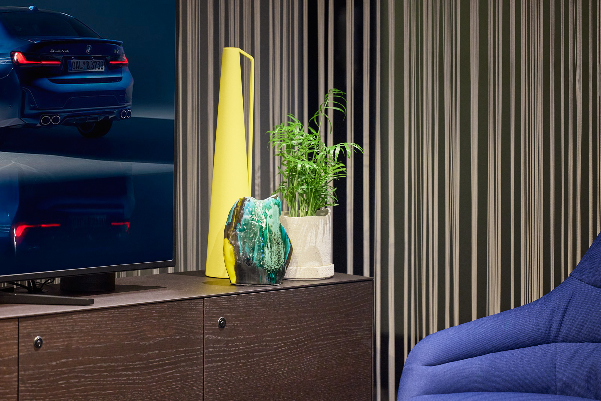 Sideboard-Dekoration neben Bildschirm, elegante Loungegestaltung im BMW Showroom.