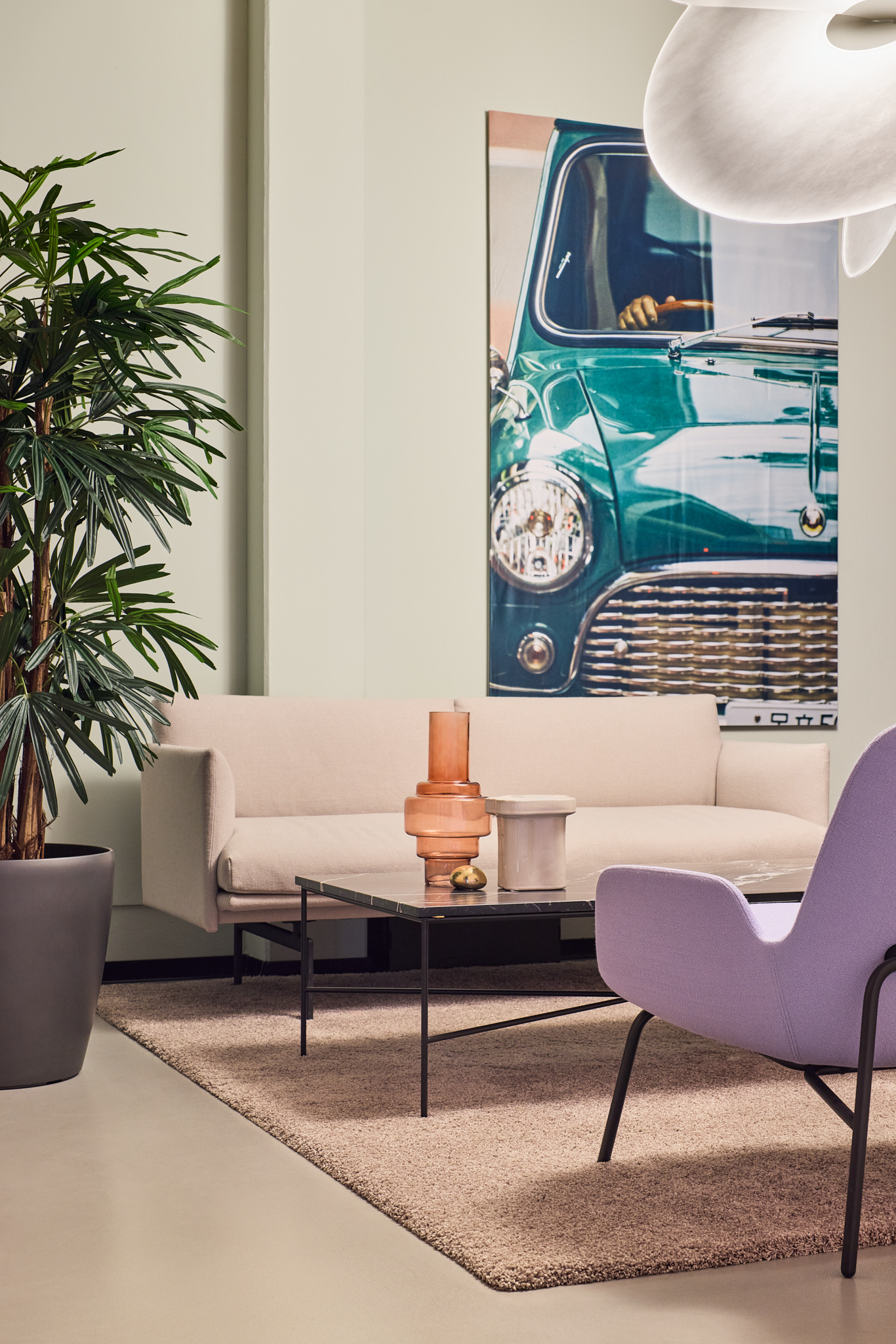 Lounge mit klassischem MINI Modell, Kunst an der Wand und Pflanzen, wohnliche Architekturfotografie.