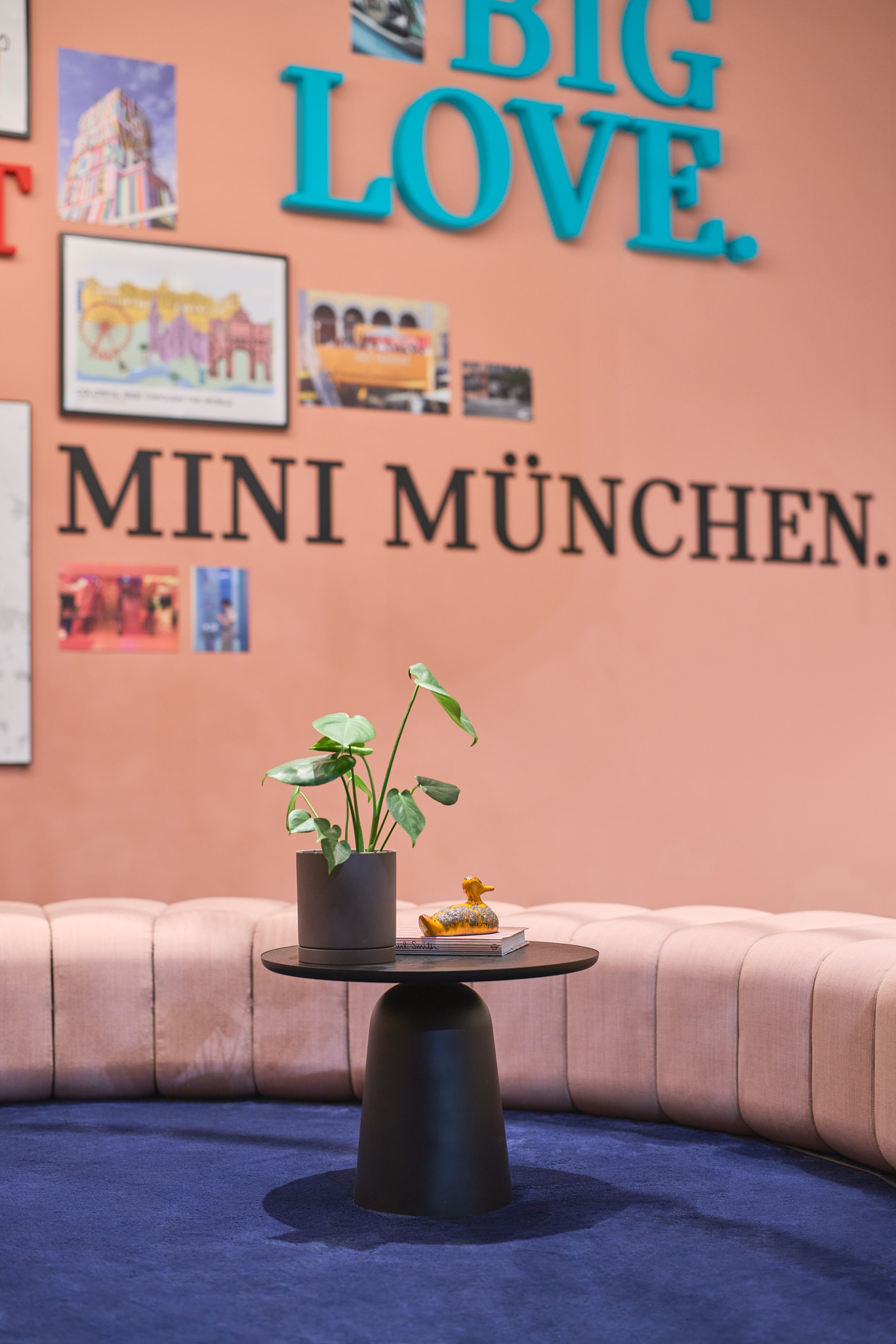 Couchtisch mit Dekoration und rosa Wand, stimmungsvolle Architekturfotografie im MINI Showroom.