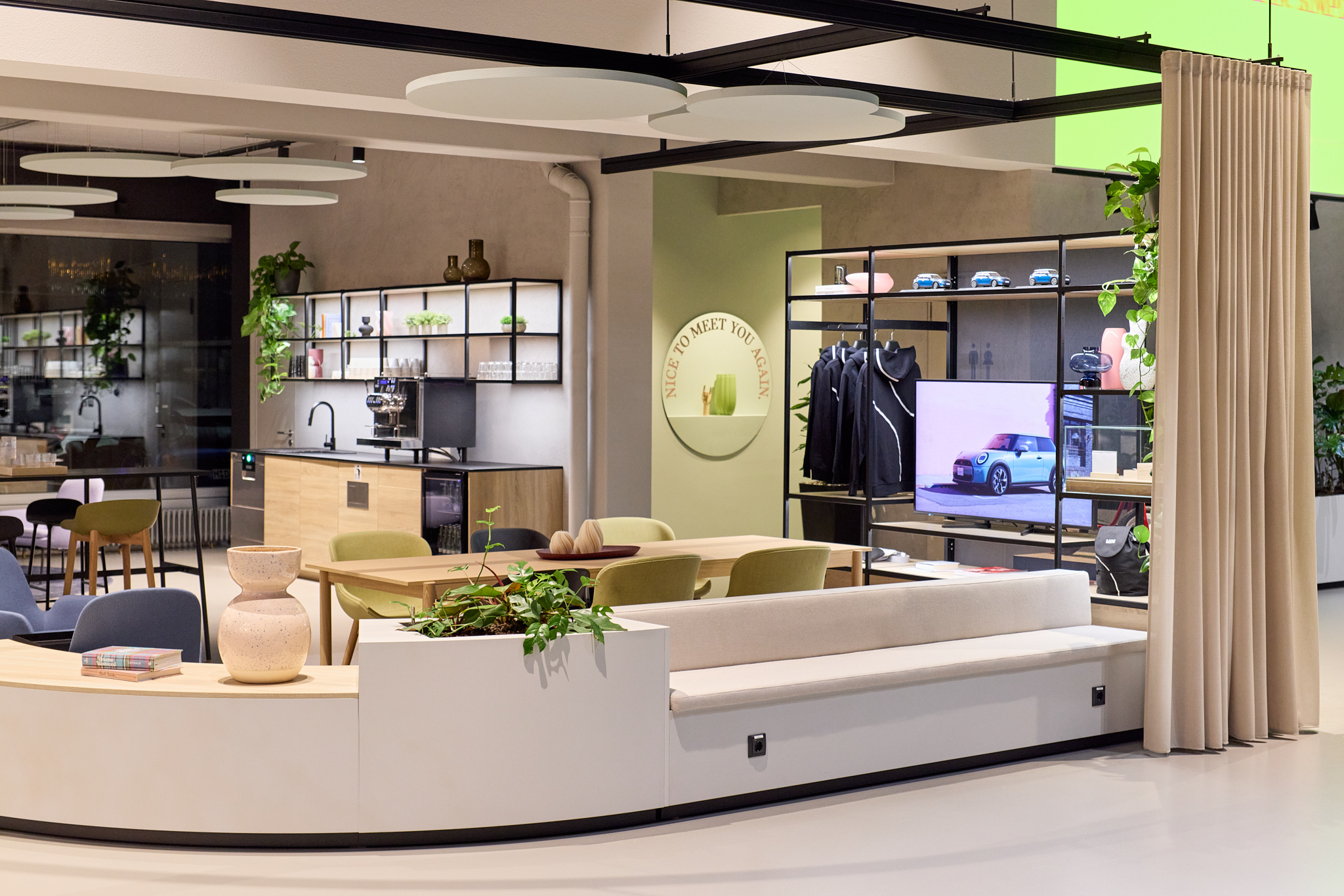 Sitzgelegenheiten und Küchenbereich im MINI Showroom, klare Linien moderner Architekturfotografie.